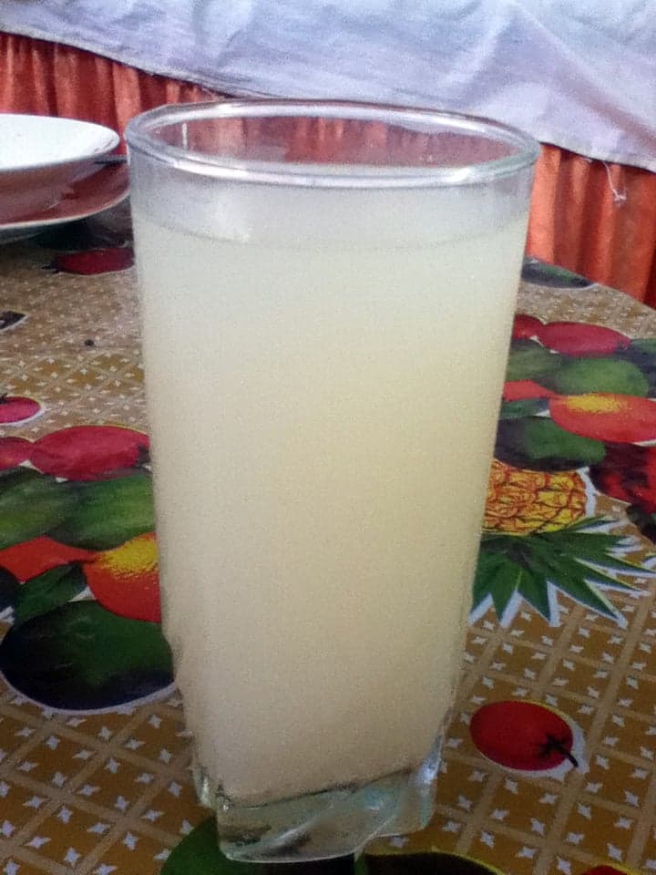 Clay pot filled with creamy pale kissangua drink on a woven mat