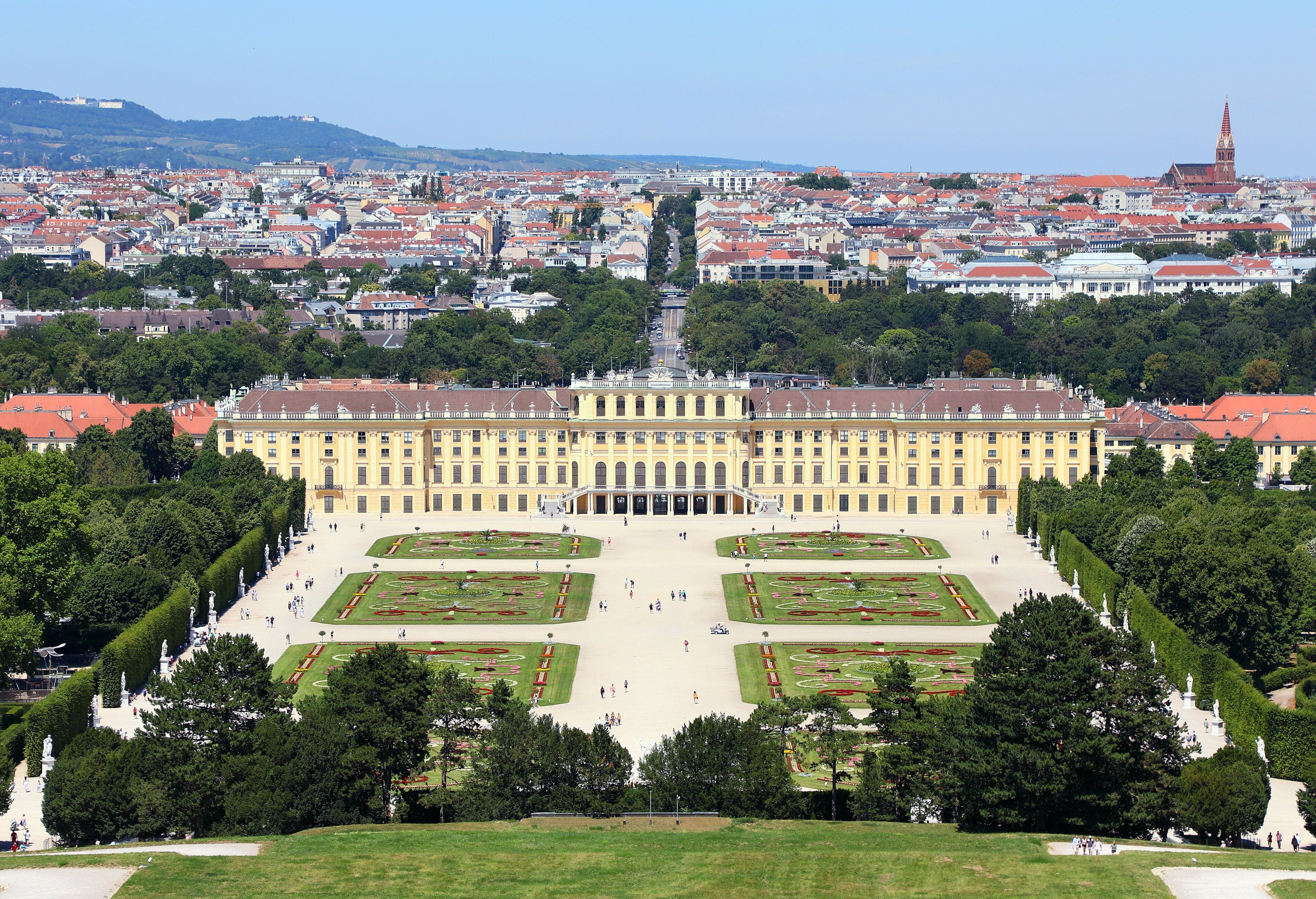 The yellow facade of Schönbrunn Palace with its grand fountain and long formal gardens