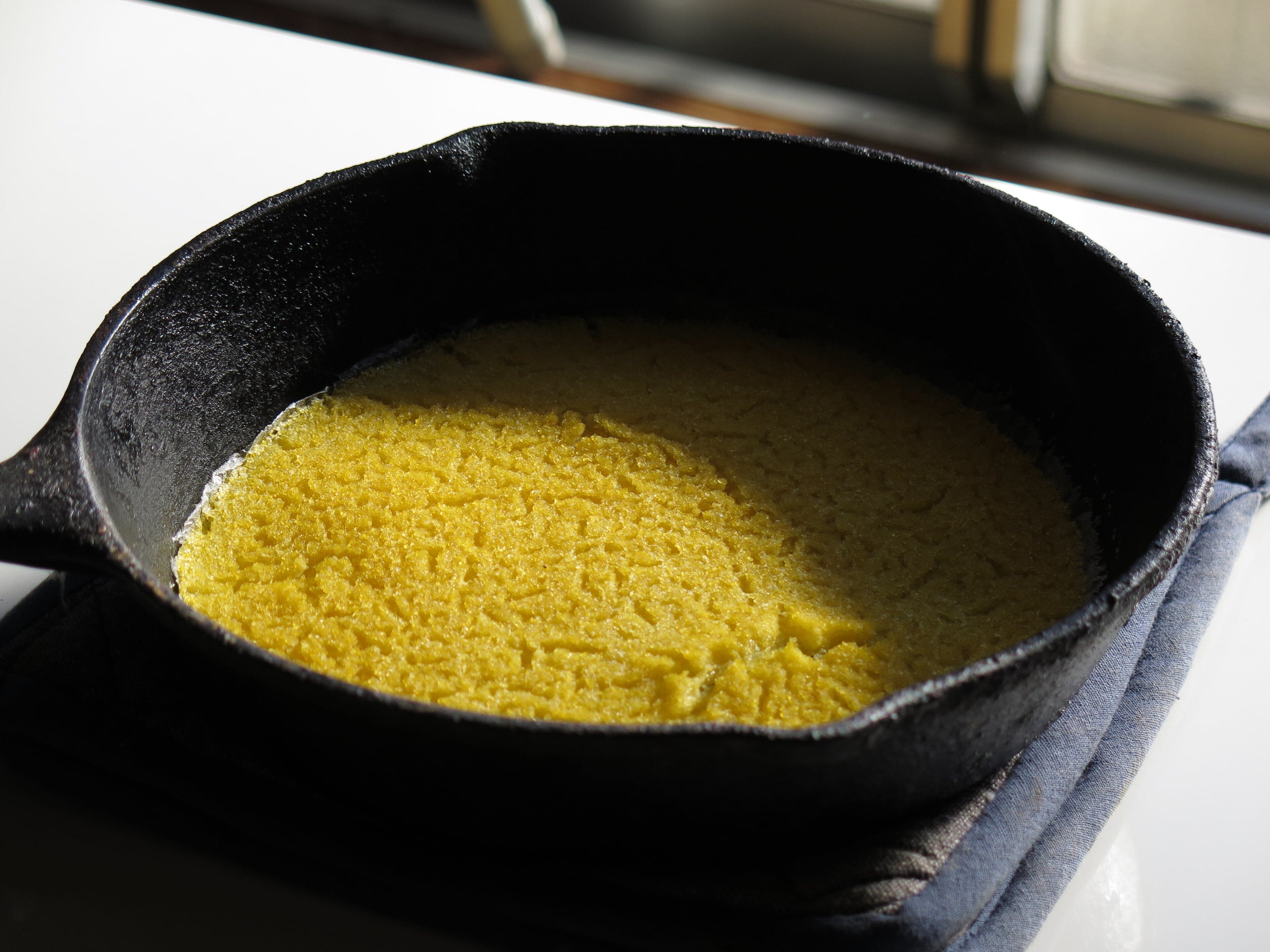 Golden rounds of johnnycake bread on a wooden board