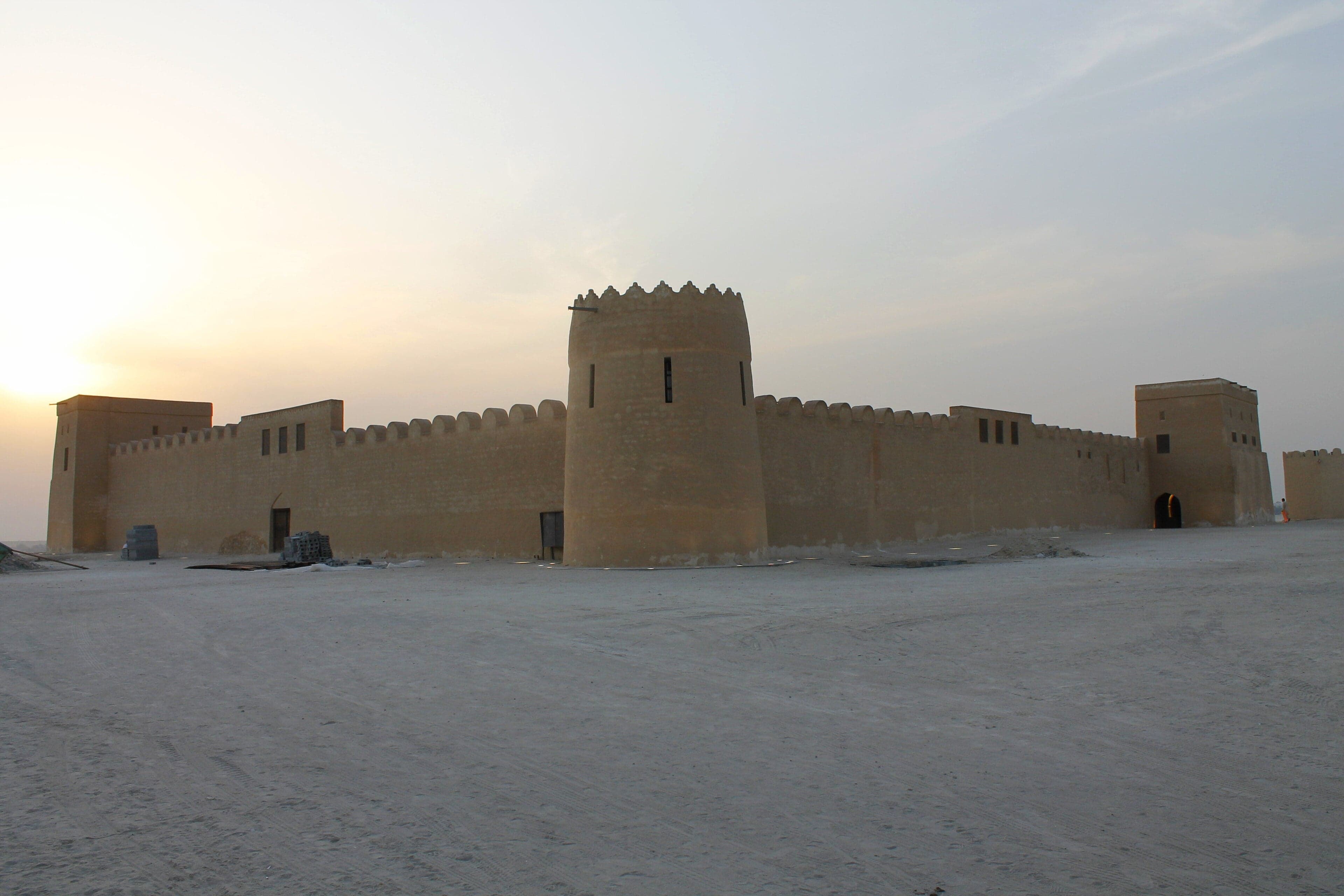 Riffa Fort sitting on a hillside overlooking a wadi and palm trees