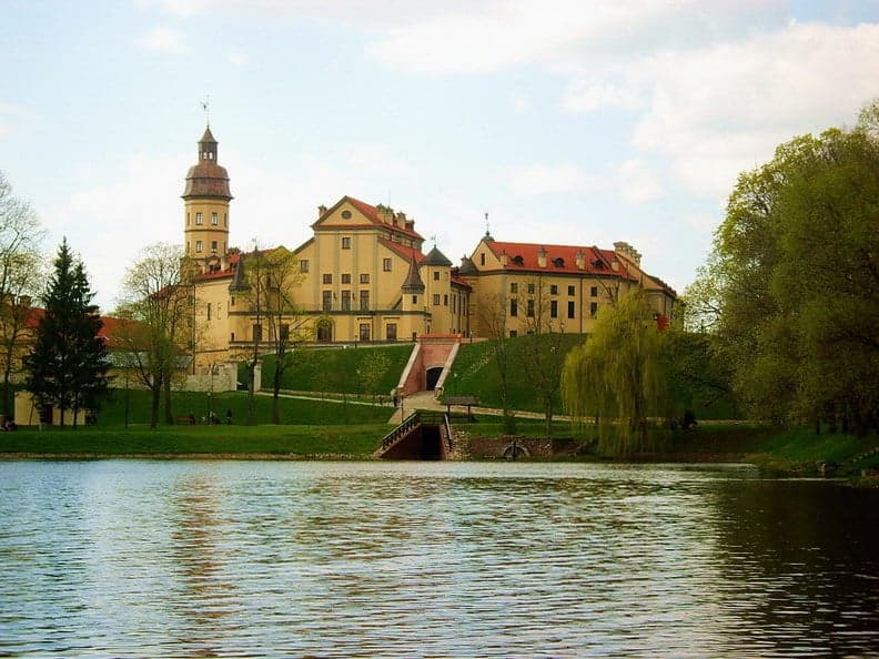 Nesvizh Castle and its formal gardens reflected in the surrounding lakes