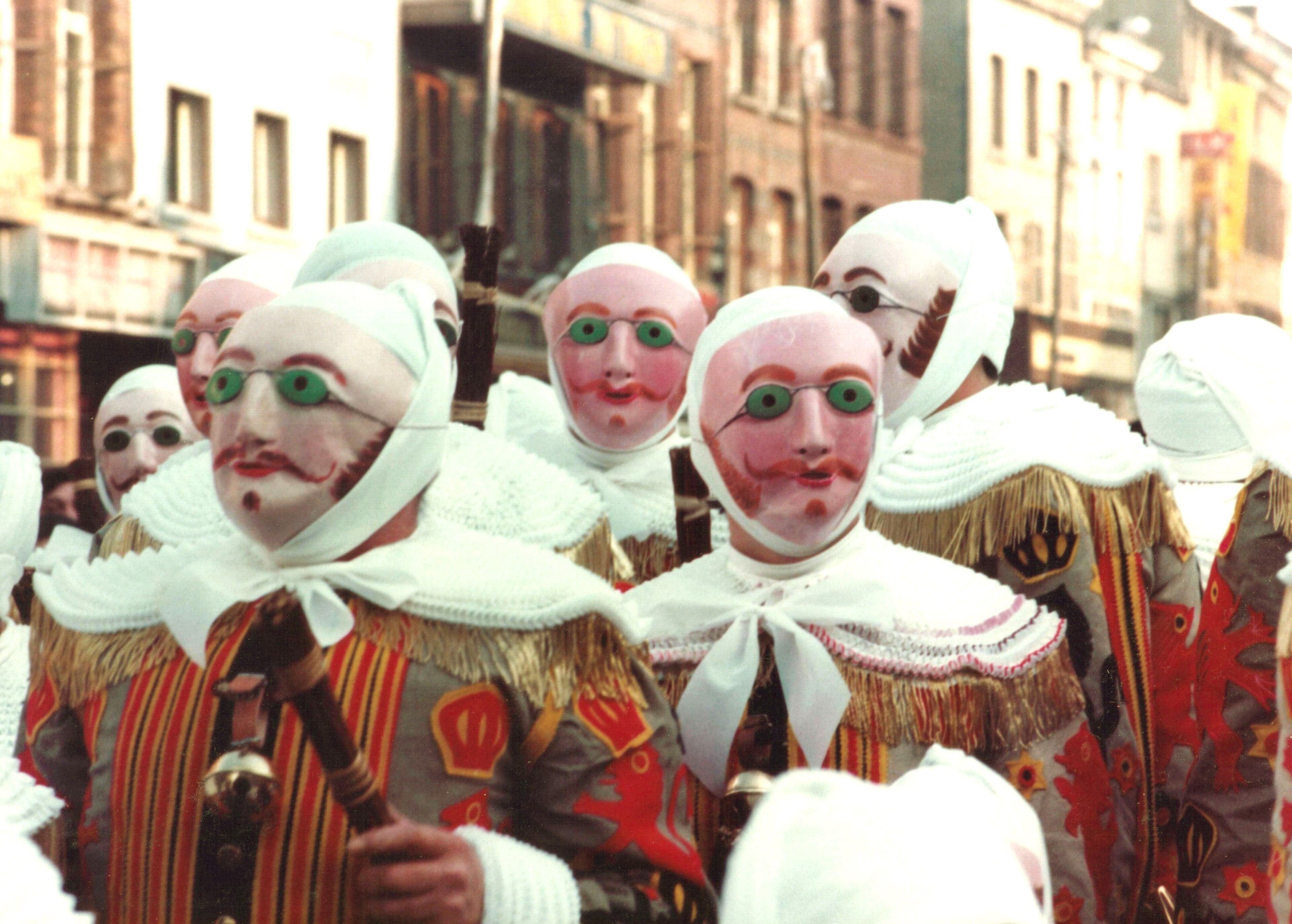 Gilles de Binche in elaborate costume with tall ostrich-feather hats parading through the street