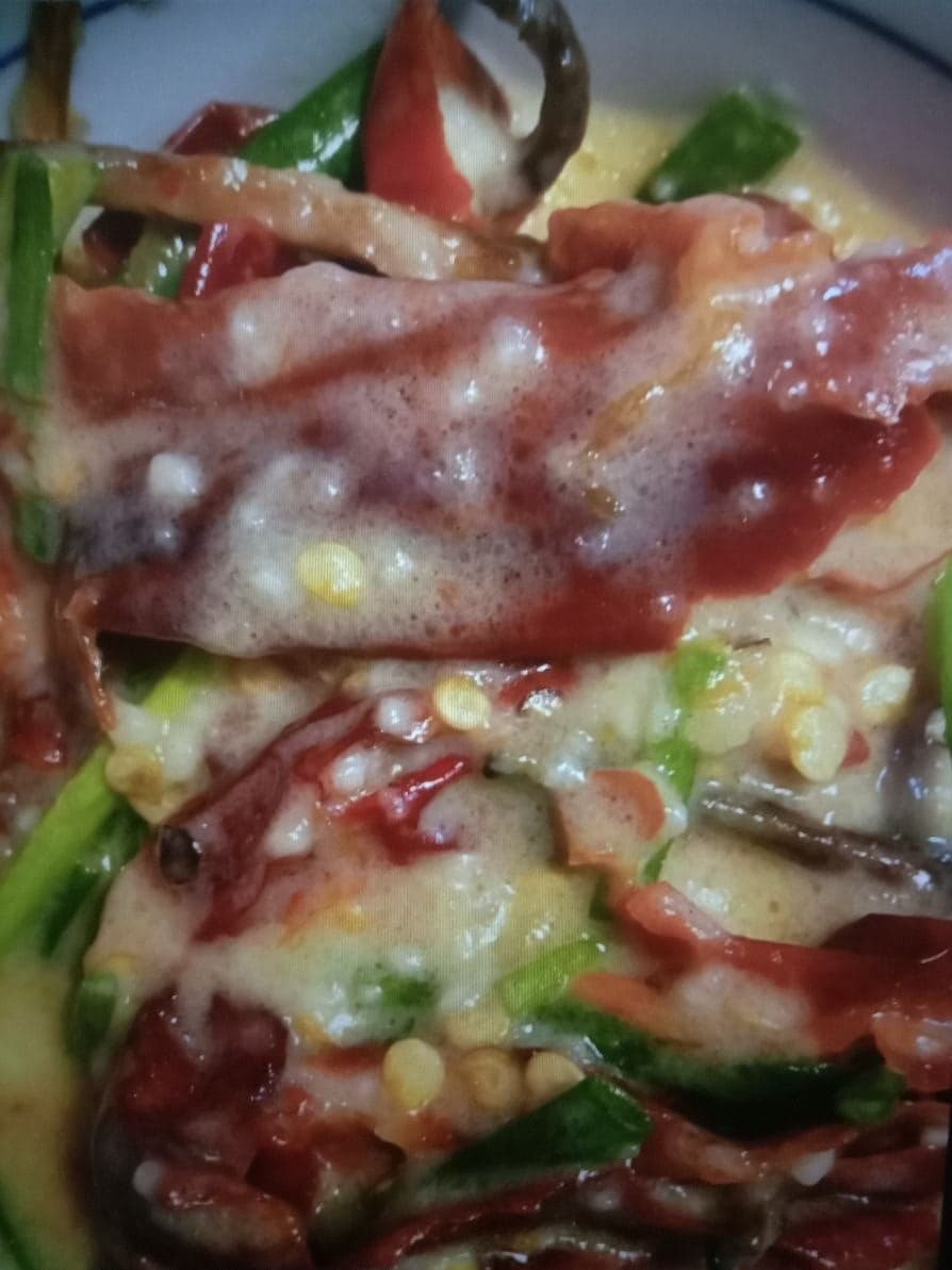 A bowl of ema datshi - bright red and green chillies cooked in a creamy cheese sauce