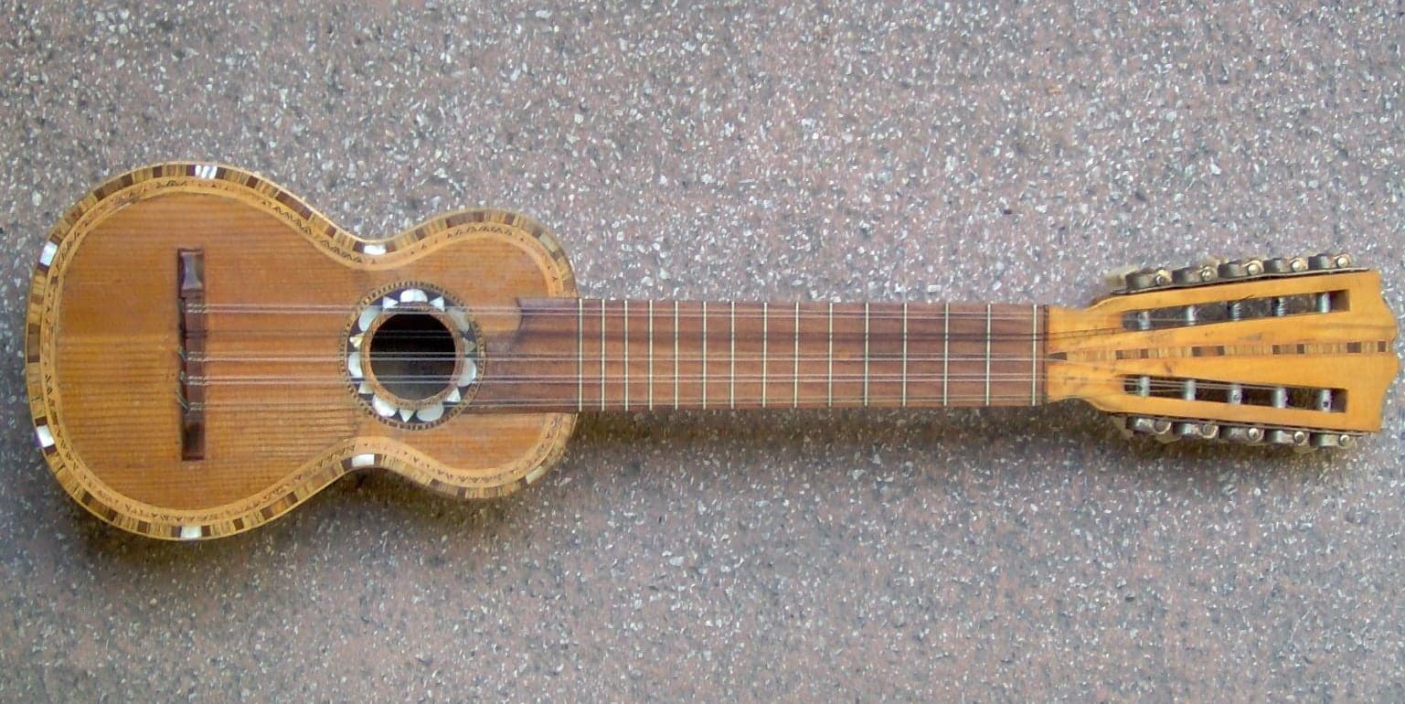 A charango with its small rounded body and ten strings being played by a musician