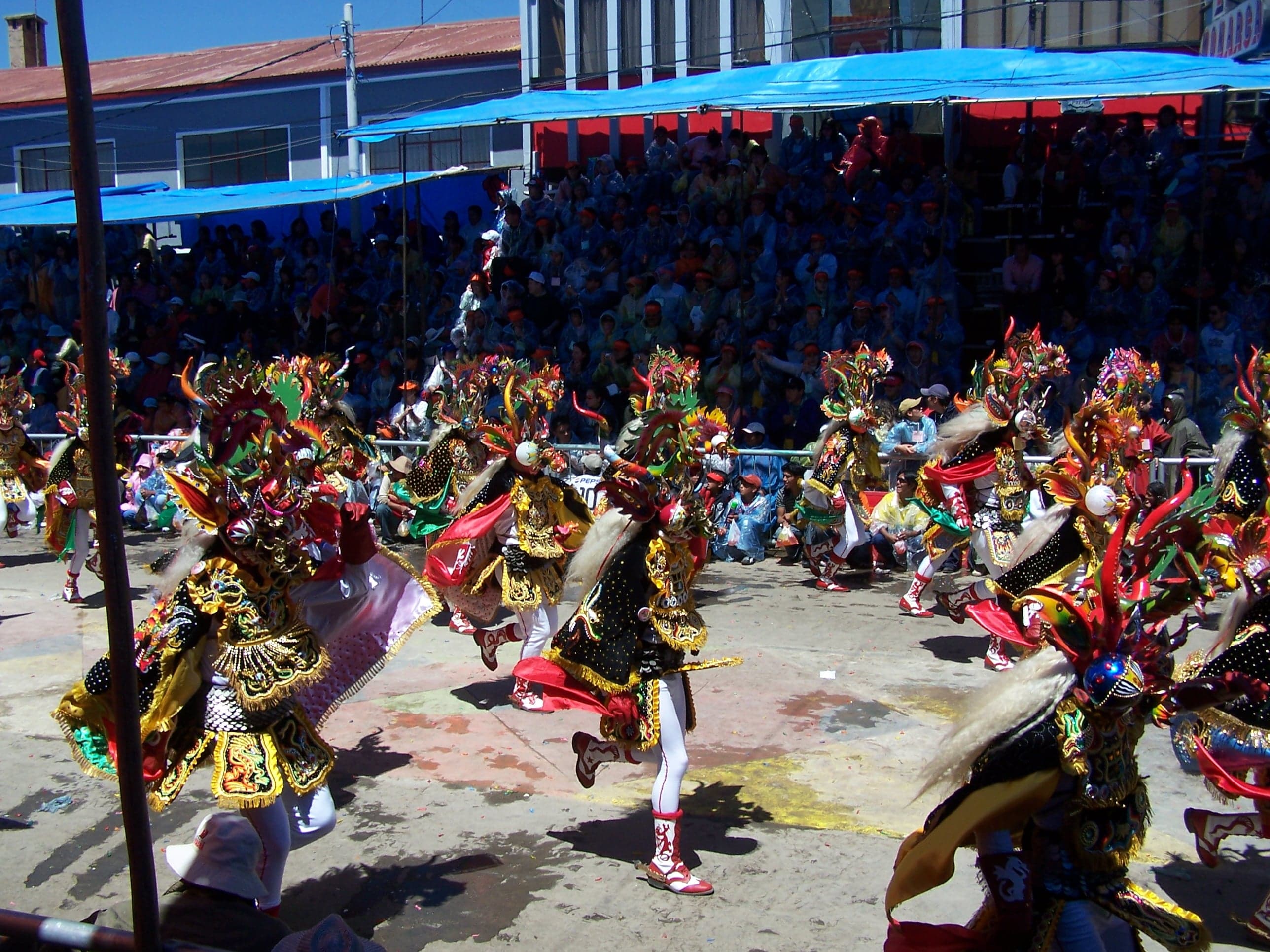 Dancers in spectacular devil costumes with tall colourful masks at the Oruro Carnival