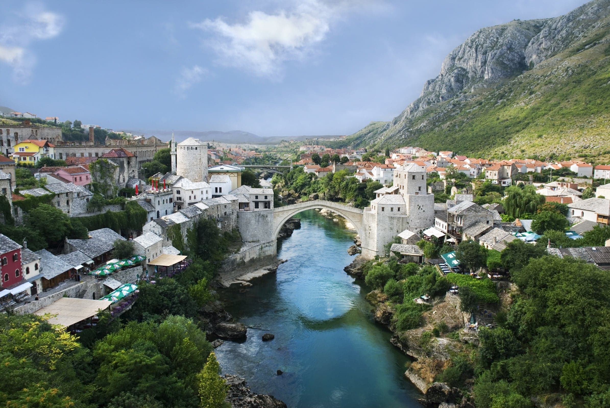 The elegant stone arch of Stari Most bridge reflecting in the blue-green Neretva River in Mostar