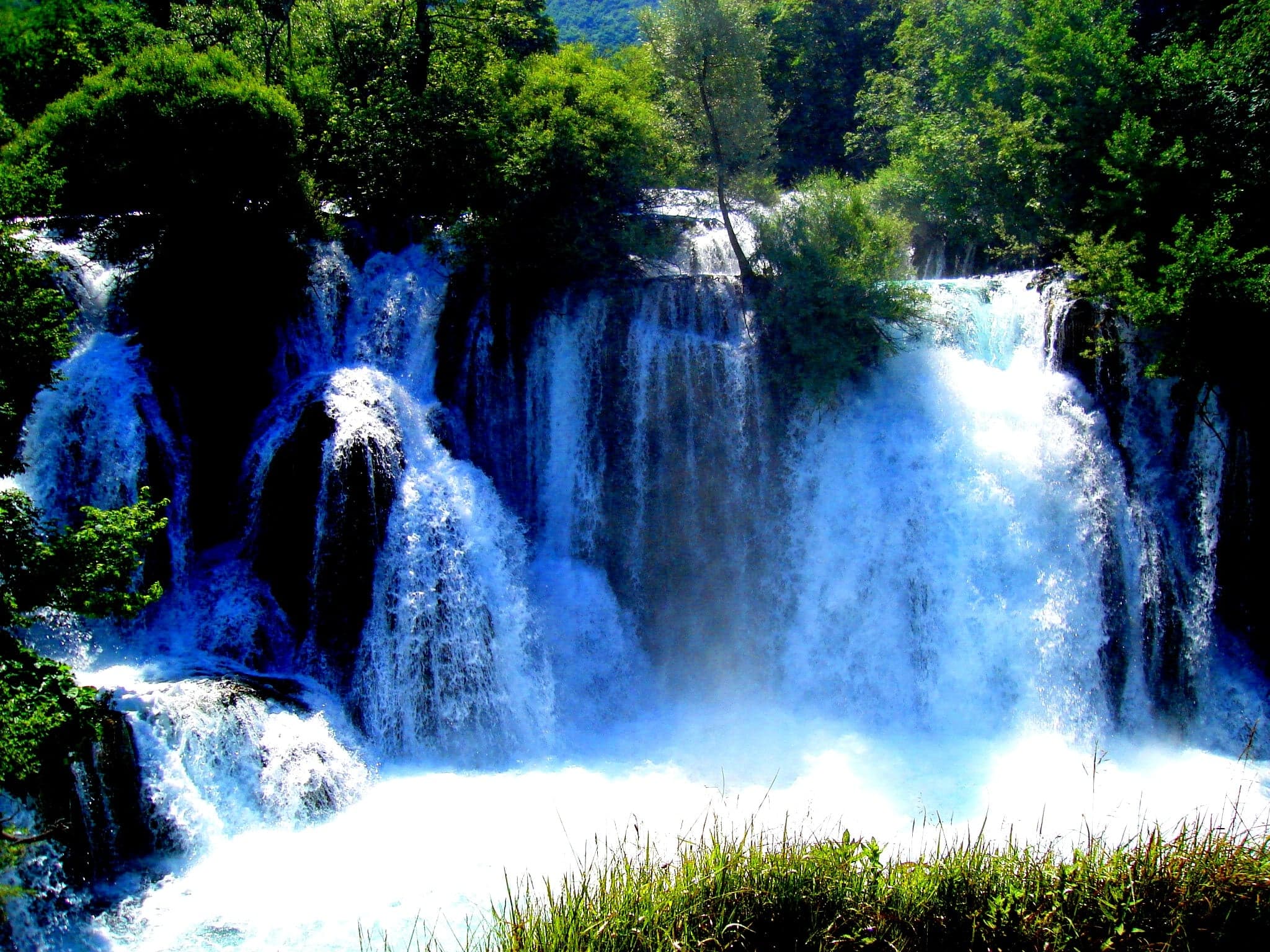 The turquoise stepped waterfalls of the Una River rushing through green forest