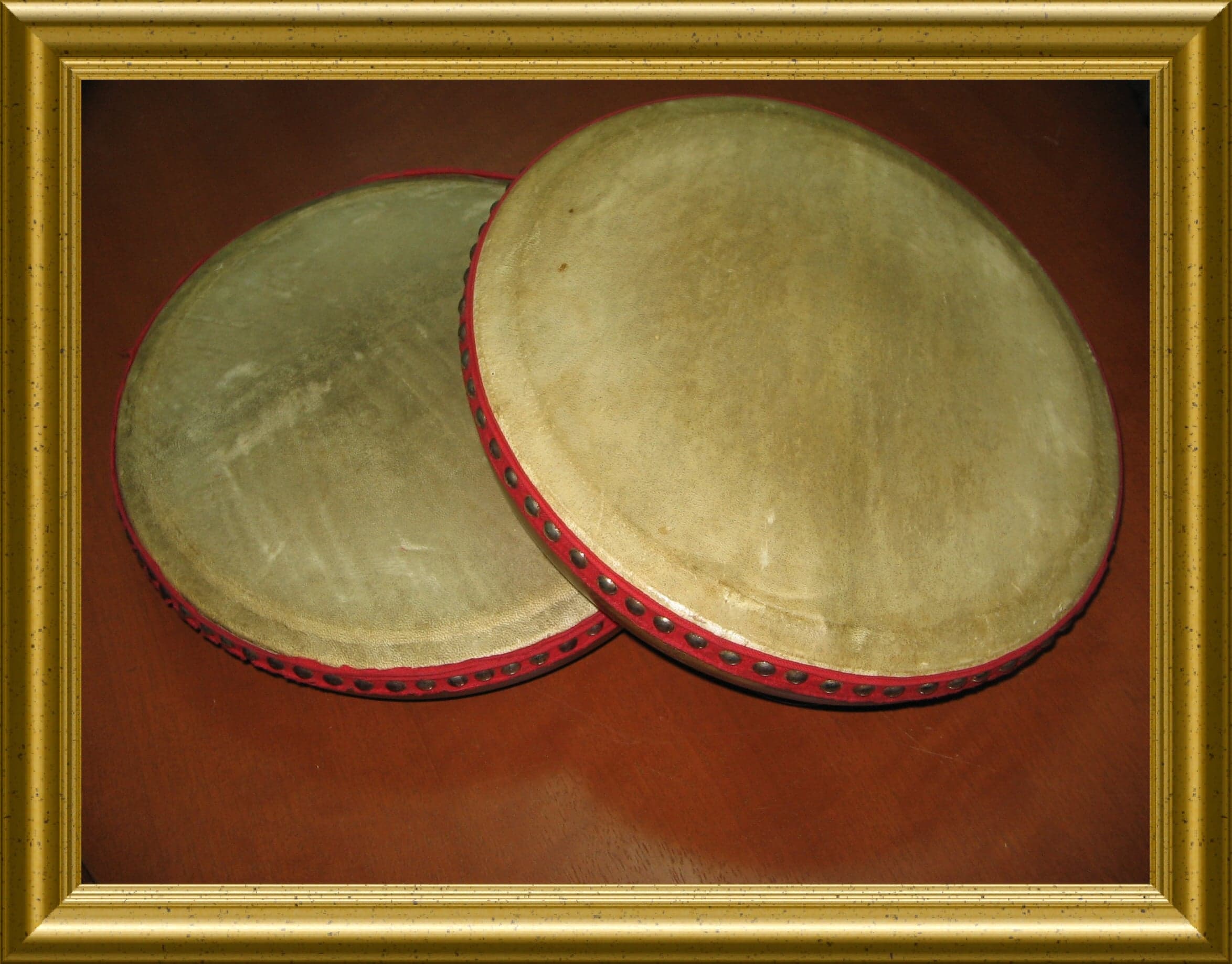 A group of musicians playing kompang drums in traditional Bruneian attire