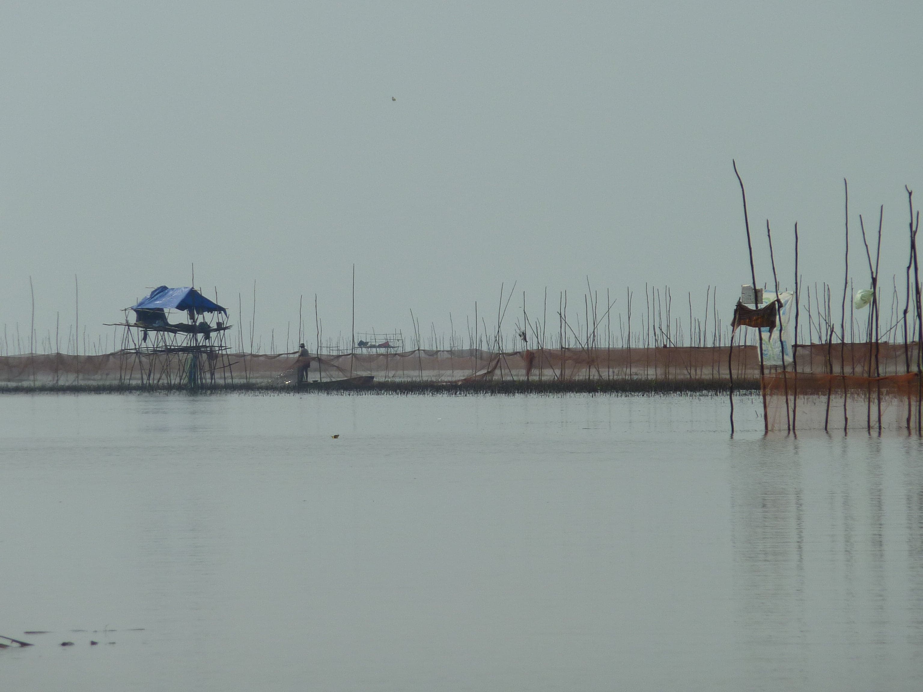 Colourful floating houses on the Tonle Sap lake with boats between them