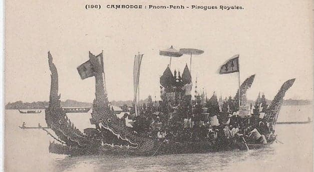 Long dragon boats racing on the Mekong River with crowds watching from the bank