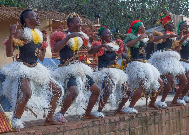 Bikutsi dancers in bright traditional dress performing to drums and balafon