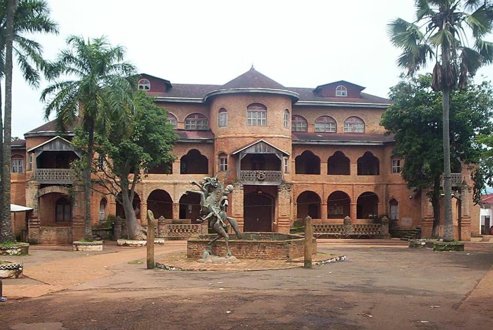The ornate facade of the Foumban Royal Palace with towers and carvings