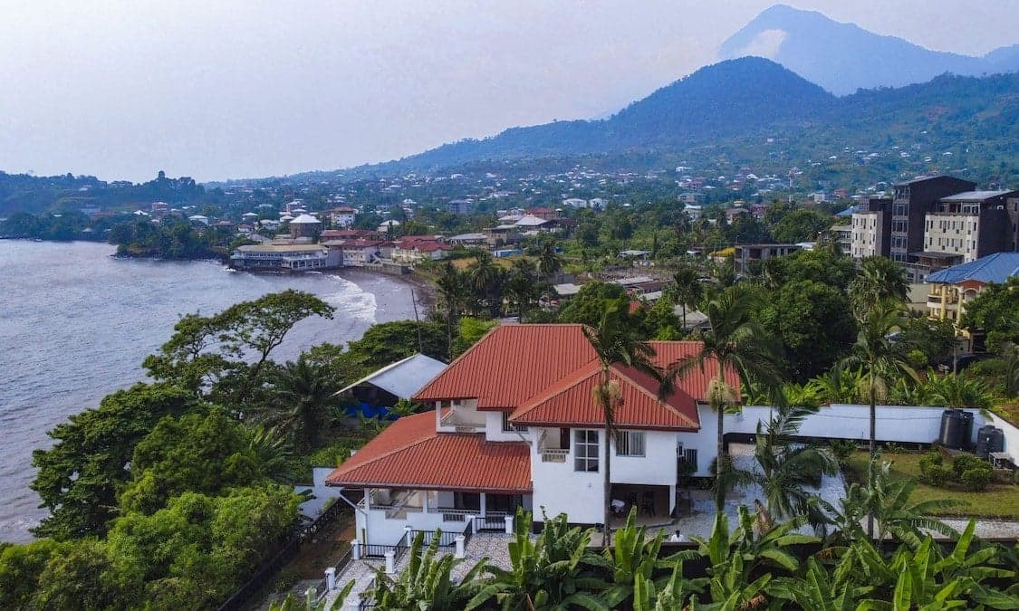 Dark volcanic sand beach at Limbe, Cameroon, with the ocean beyond