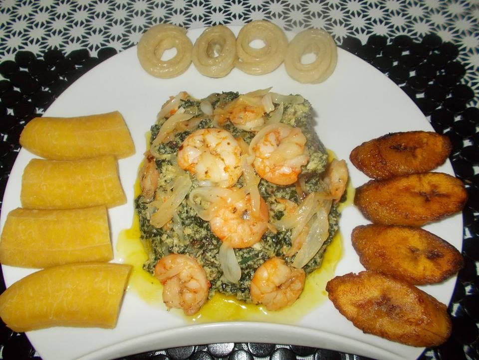 A pot of ndolé bitterleaf stew with prawns and peanuts on a table