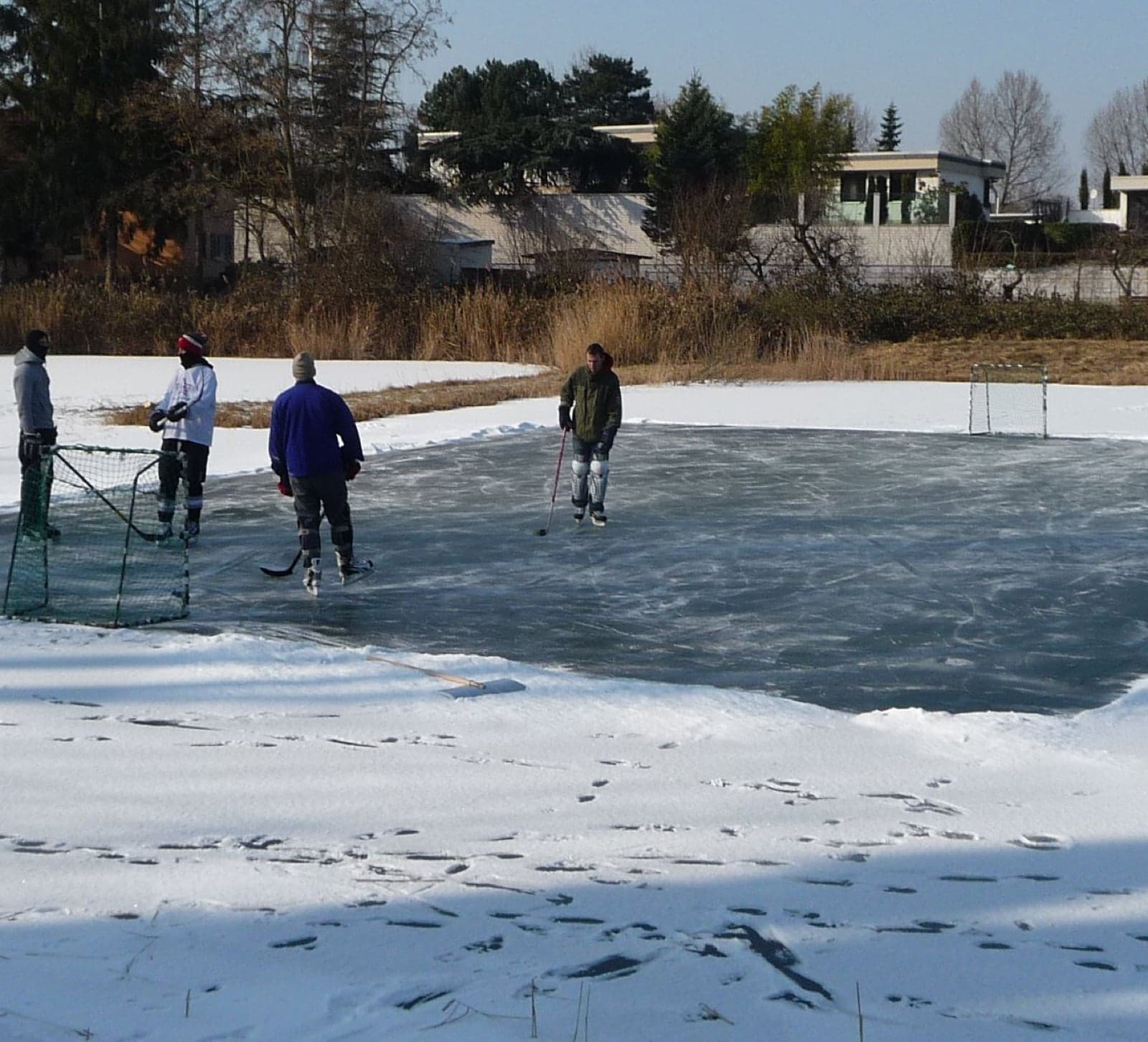 Children playing pond hockey on a frozen outdoor rink