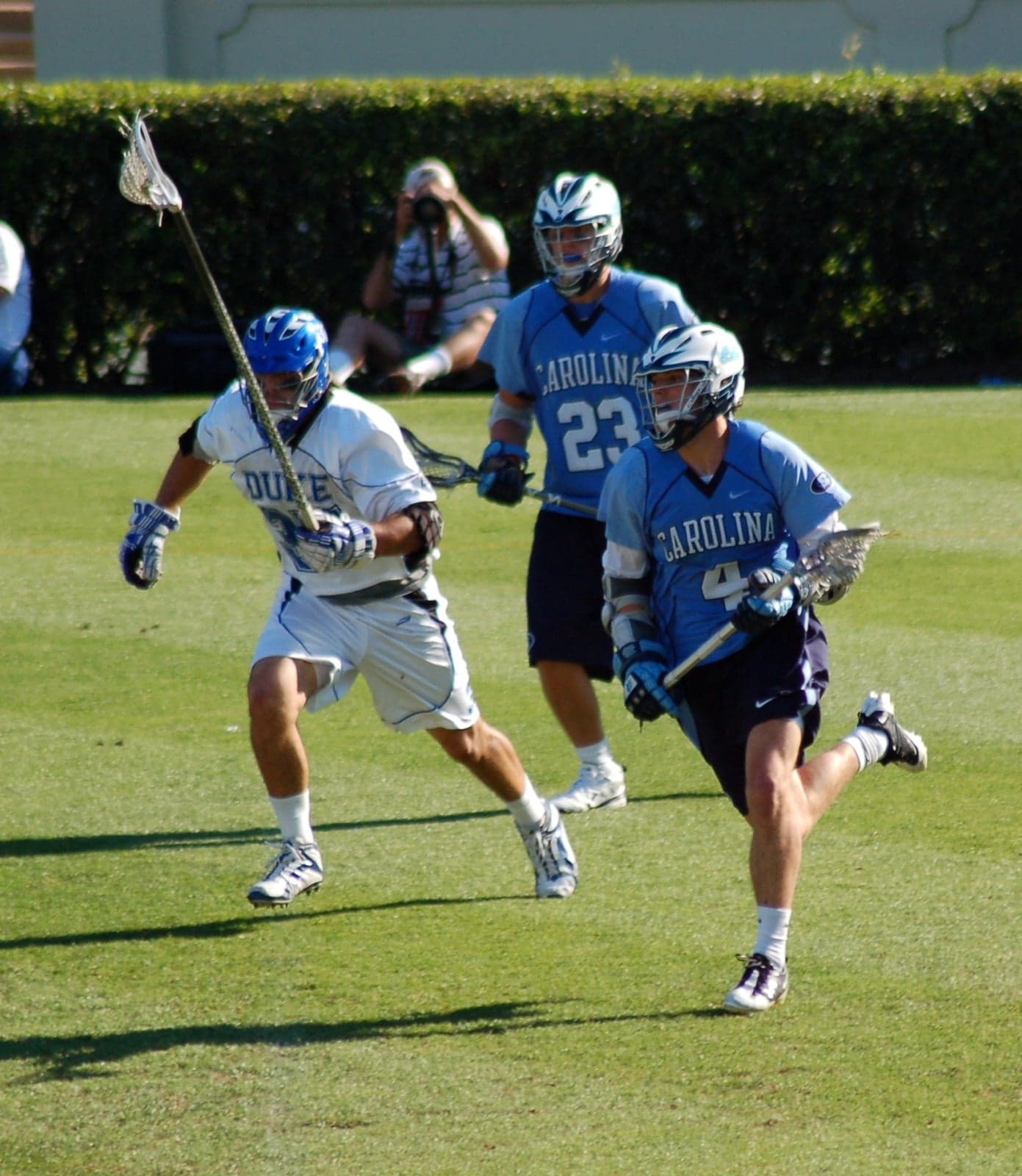 Players running with lacrosse sticks during a match