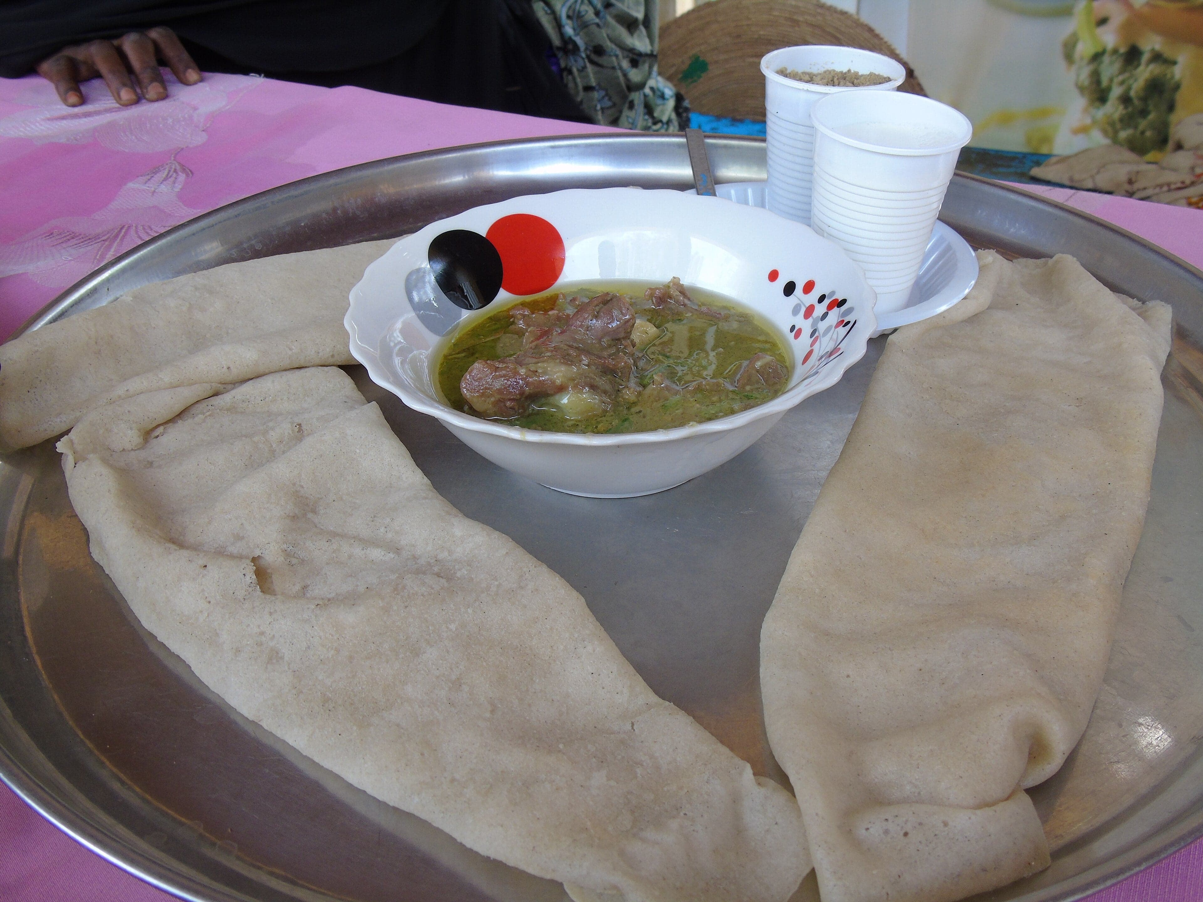 A deep pot of dark green daraba stew with okra and peanuts, served alongside boule