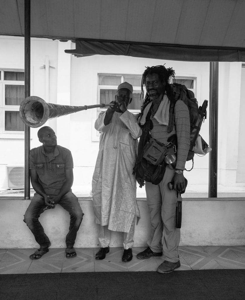 Musicians holding long metal kakaki trumpets at a traditional celebration