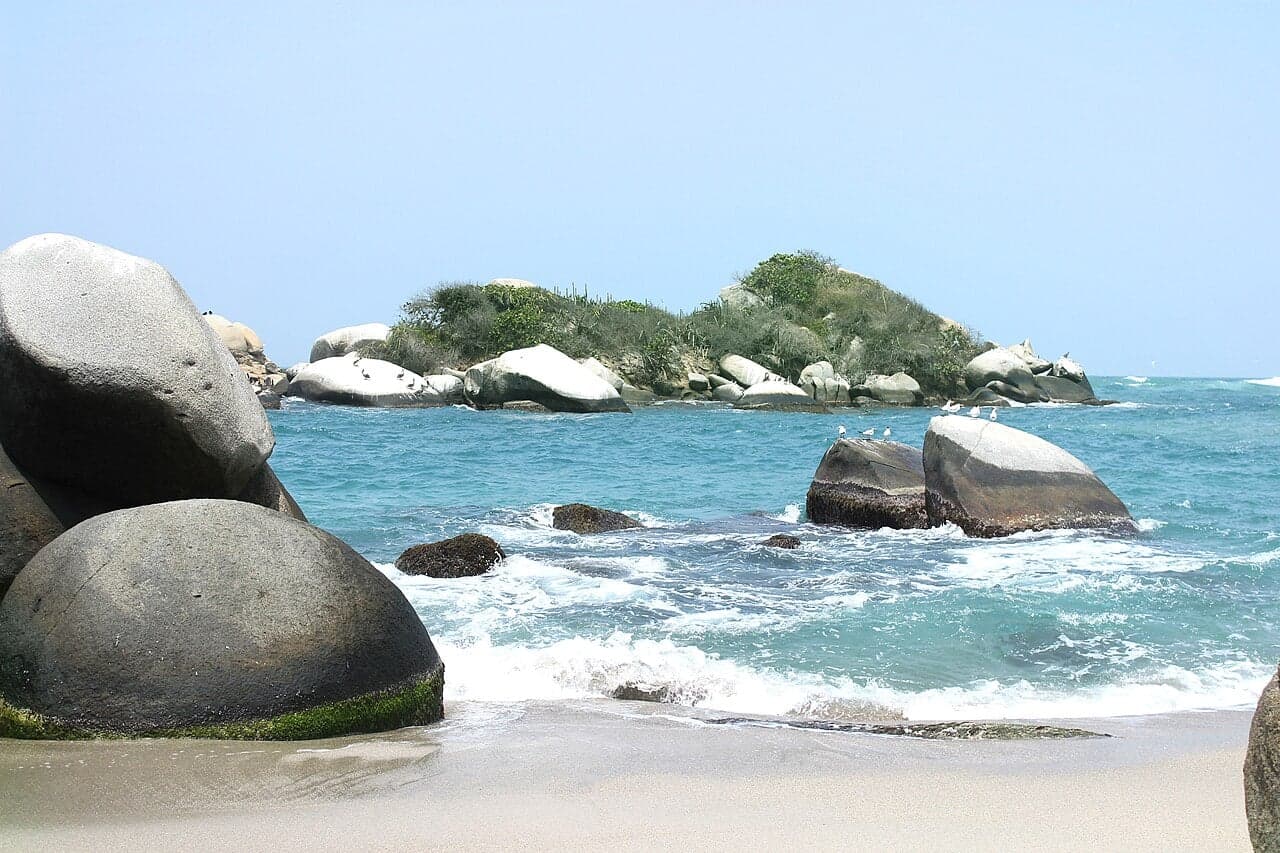 A turquoise Caribbean bay with white sand and palm trees in Colombia