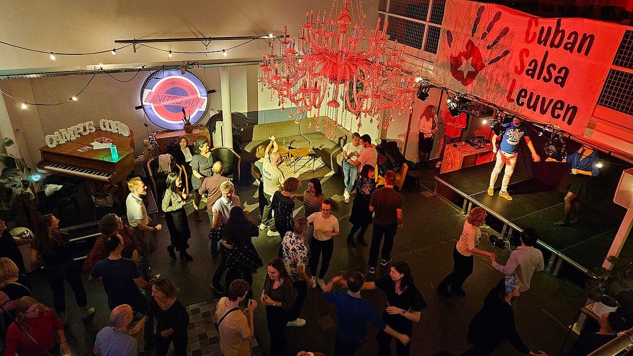 A pair of salsa dancers mid-spin on a Cuban dance floor with colourful lights