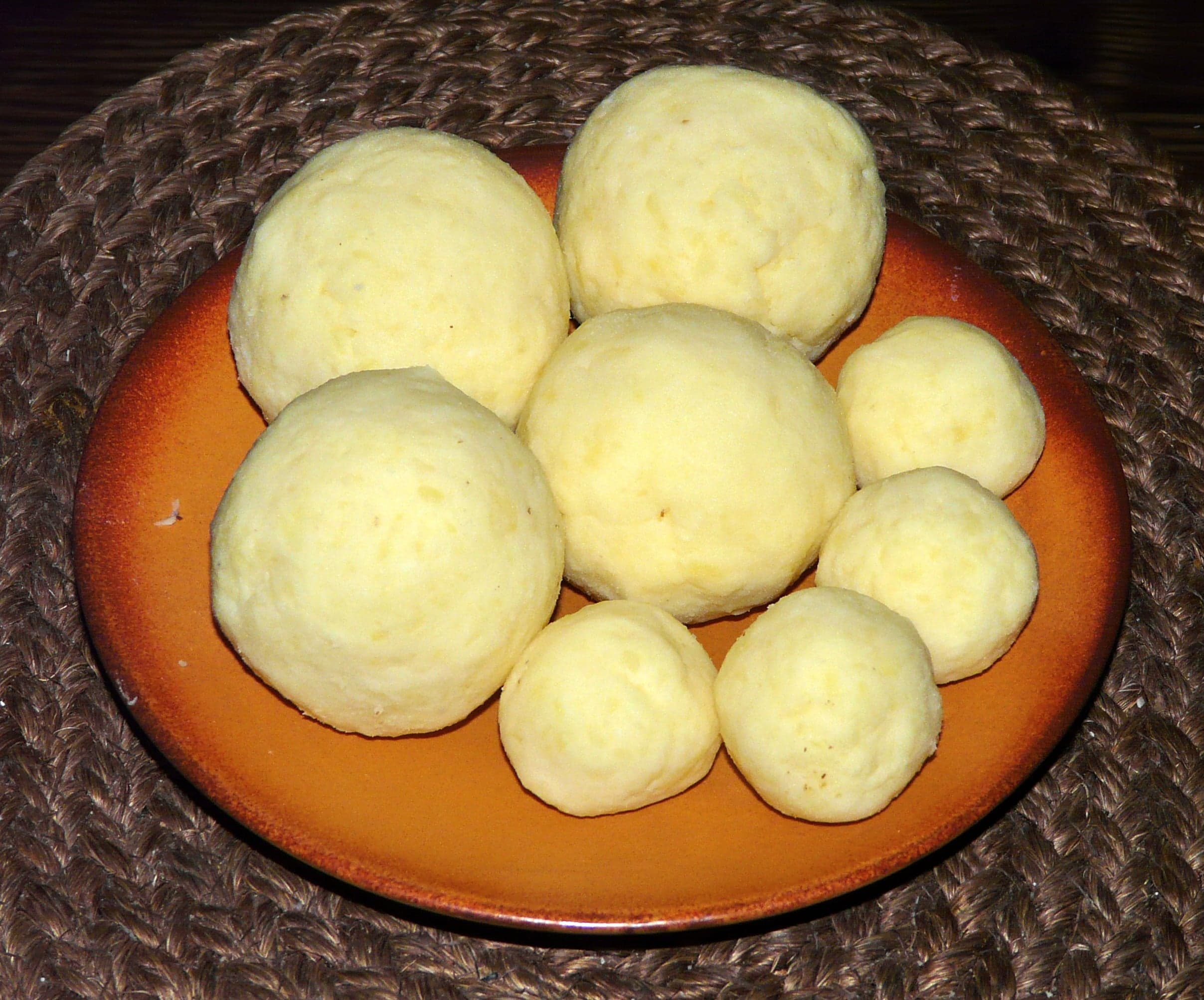 Sliced Czech bread dumplings arranged on a plate beside a hearty stew