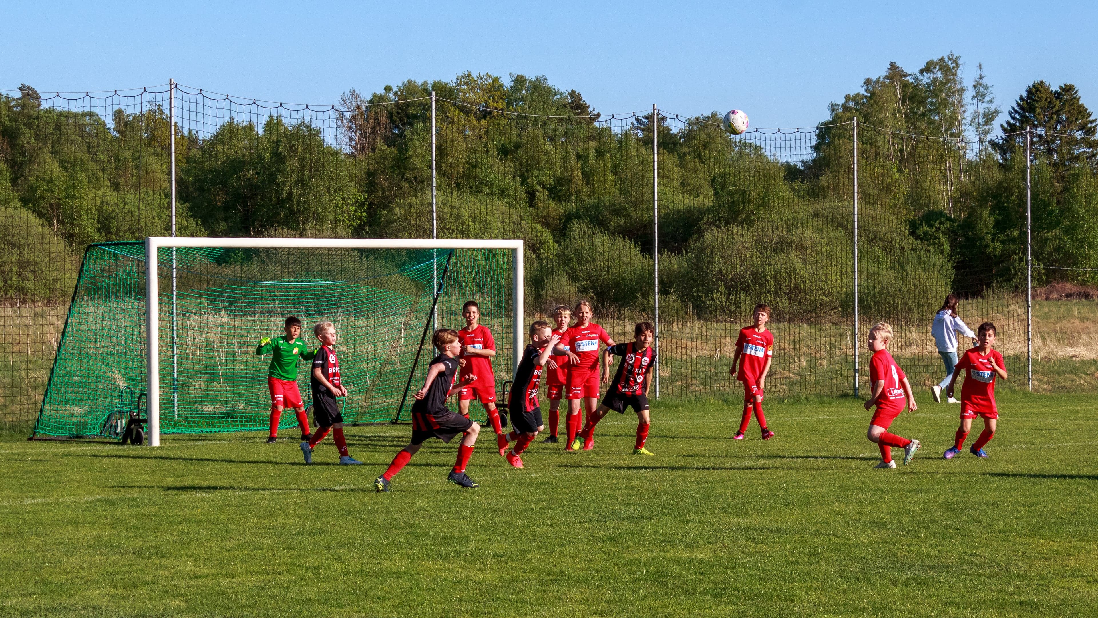 Children playing football on a grass pitch