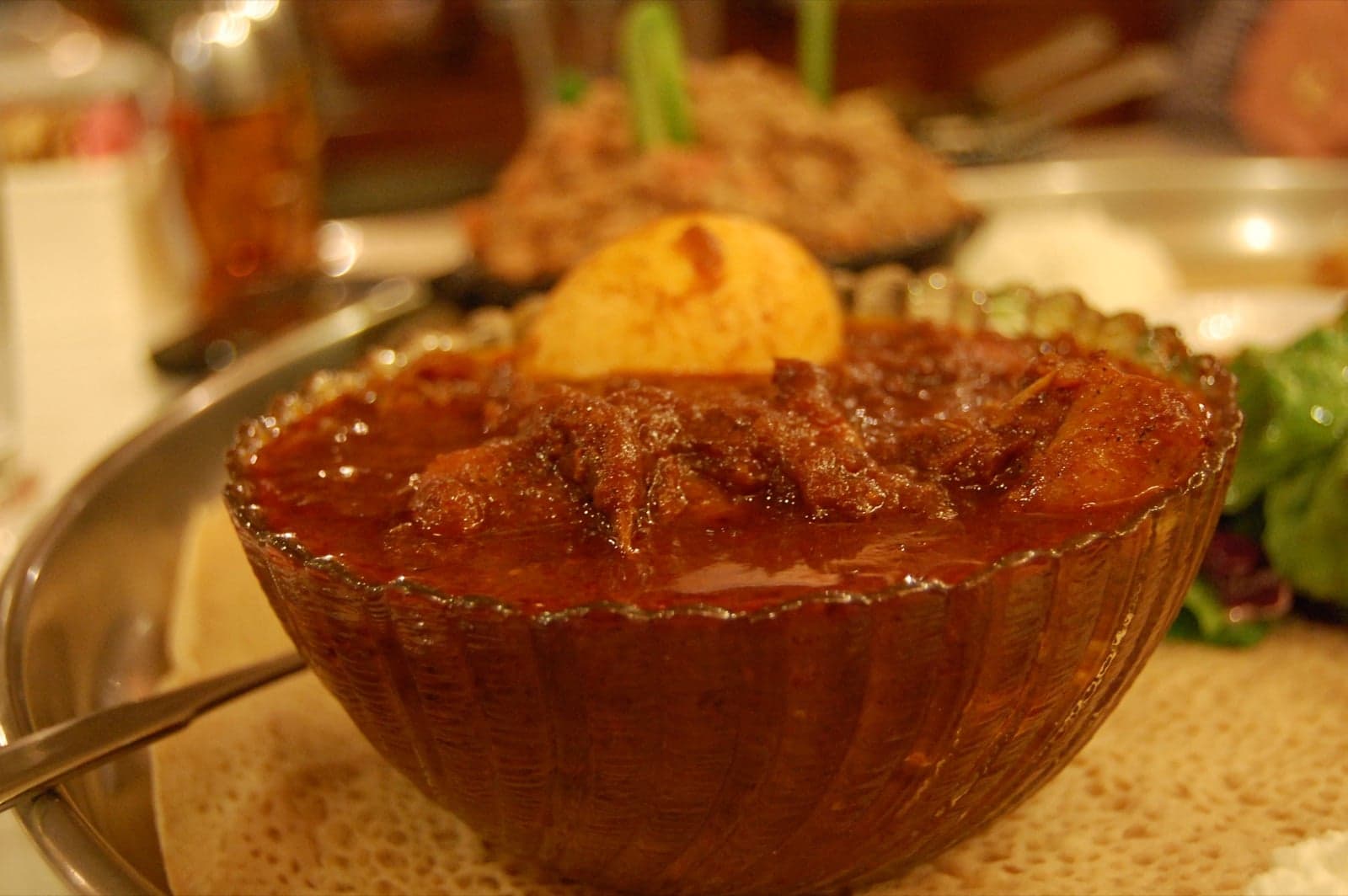 A bowl of doro wat - rich red chicken stew with a boiled egg