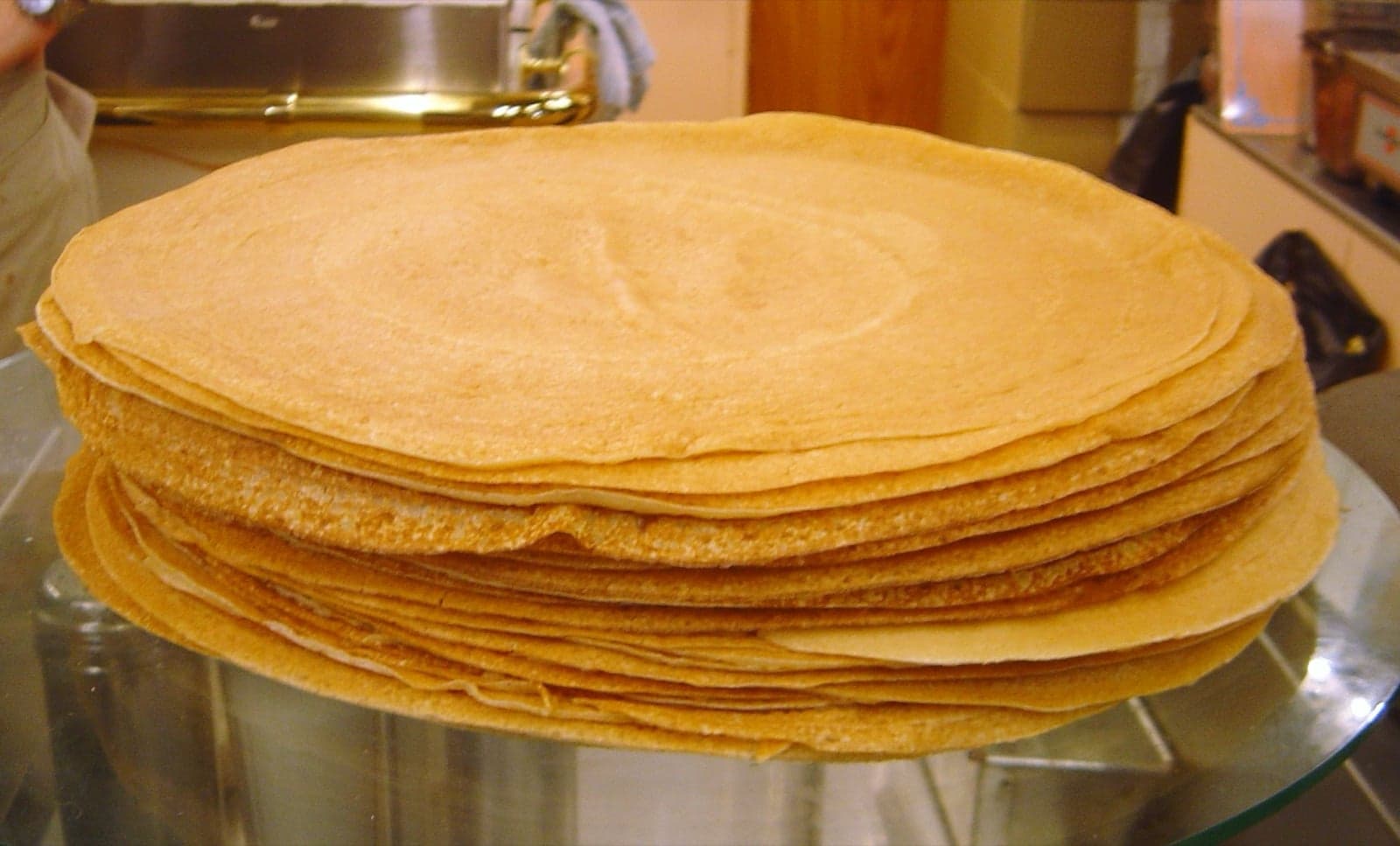 A tall stack of thin golden crêpes