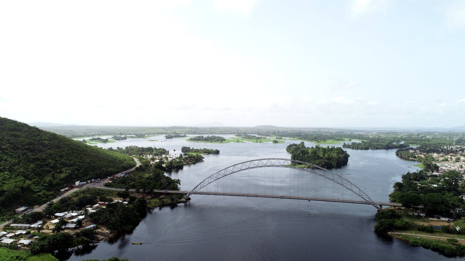 The wide waters of Lake Volta in Ghana, with green hills on the shore