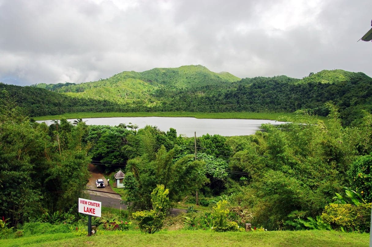 Grand Etang crater lake surrounded by lush rainforest with mist hanging over the water