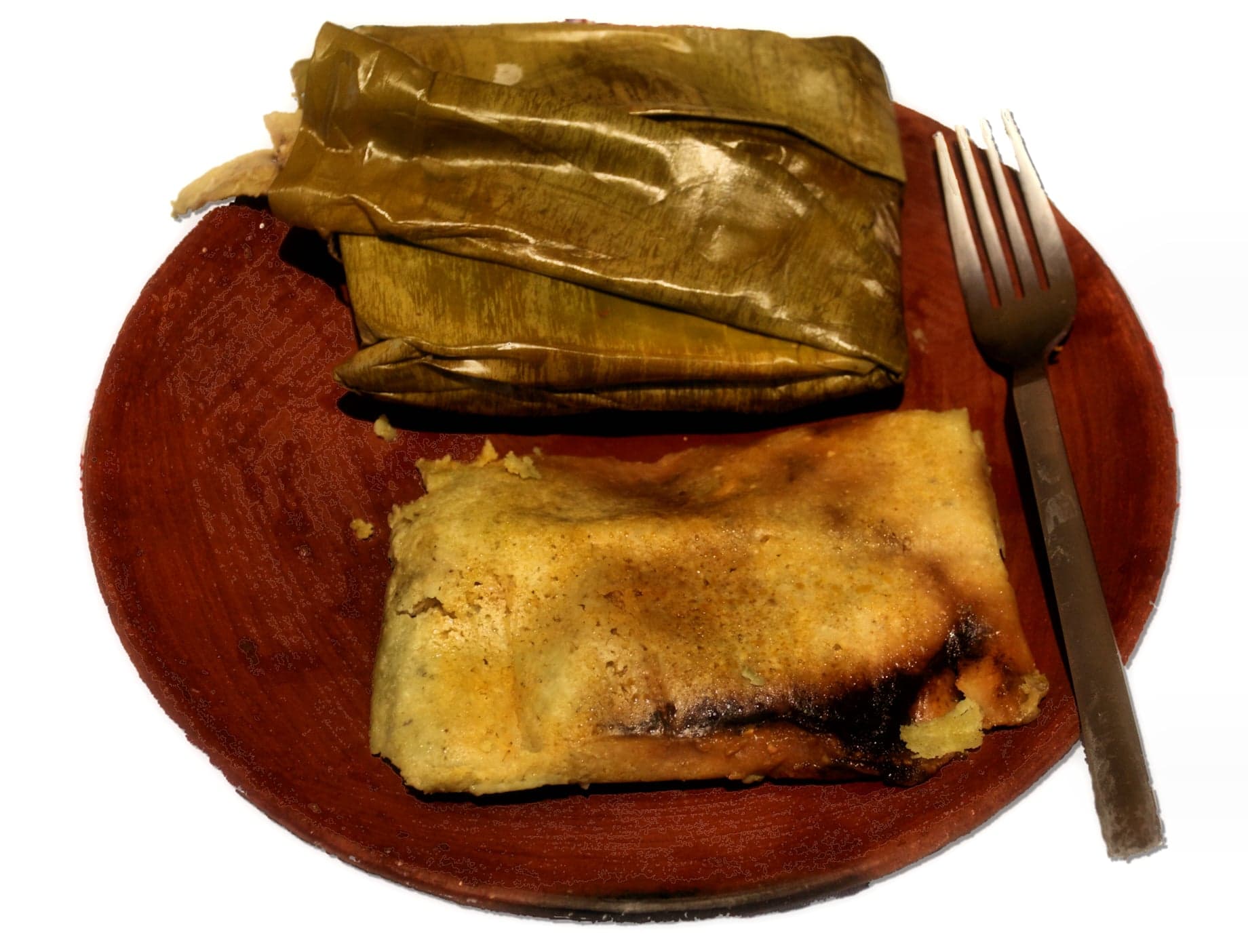 Guatemalan tamales wrapped in banana leaves, ready to steam