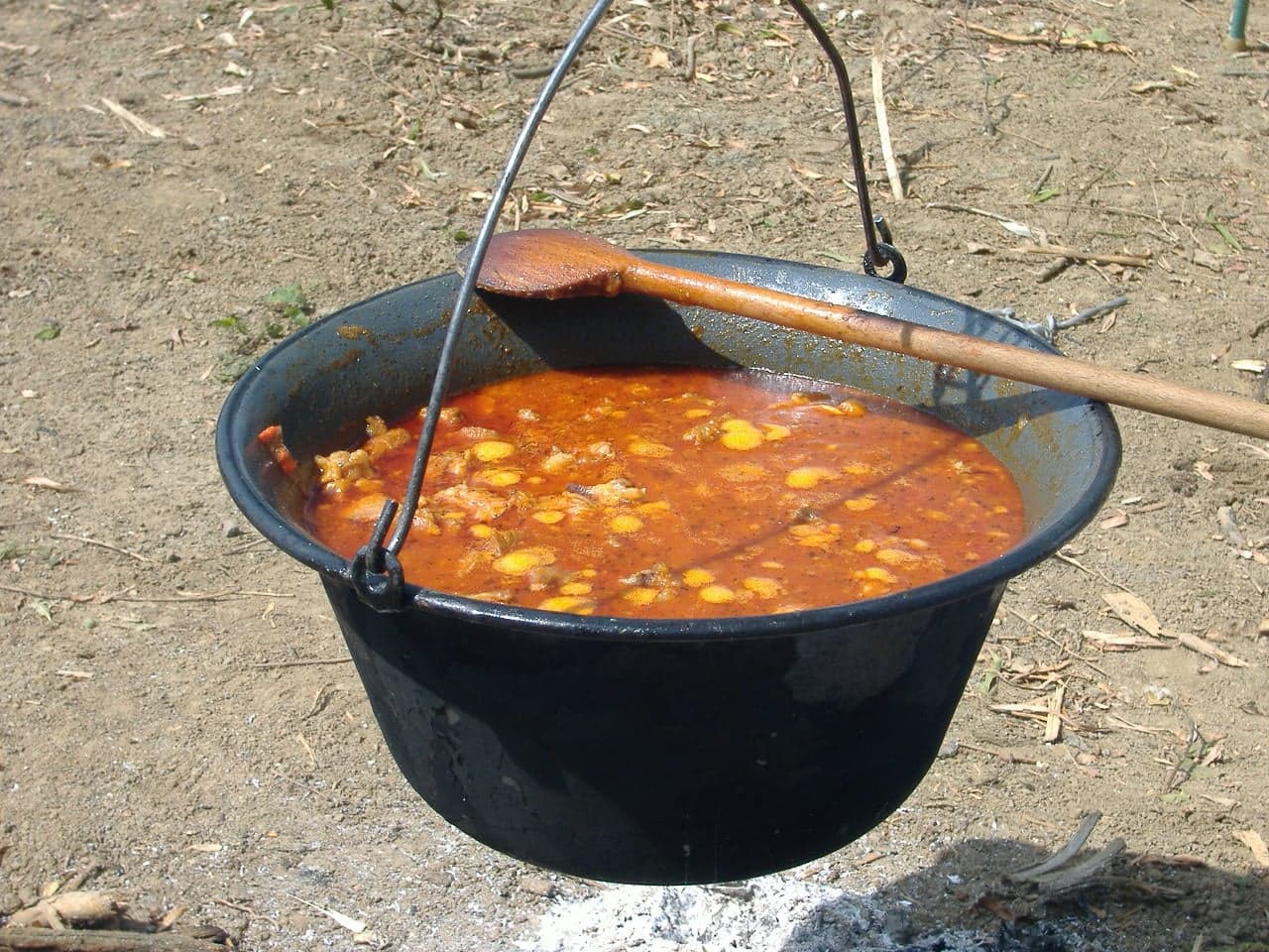 A bowl of rich red Hungarian goulash with chunks of beef and potato