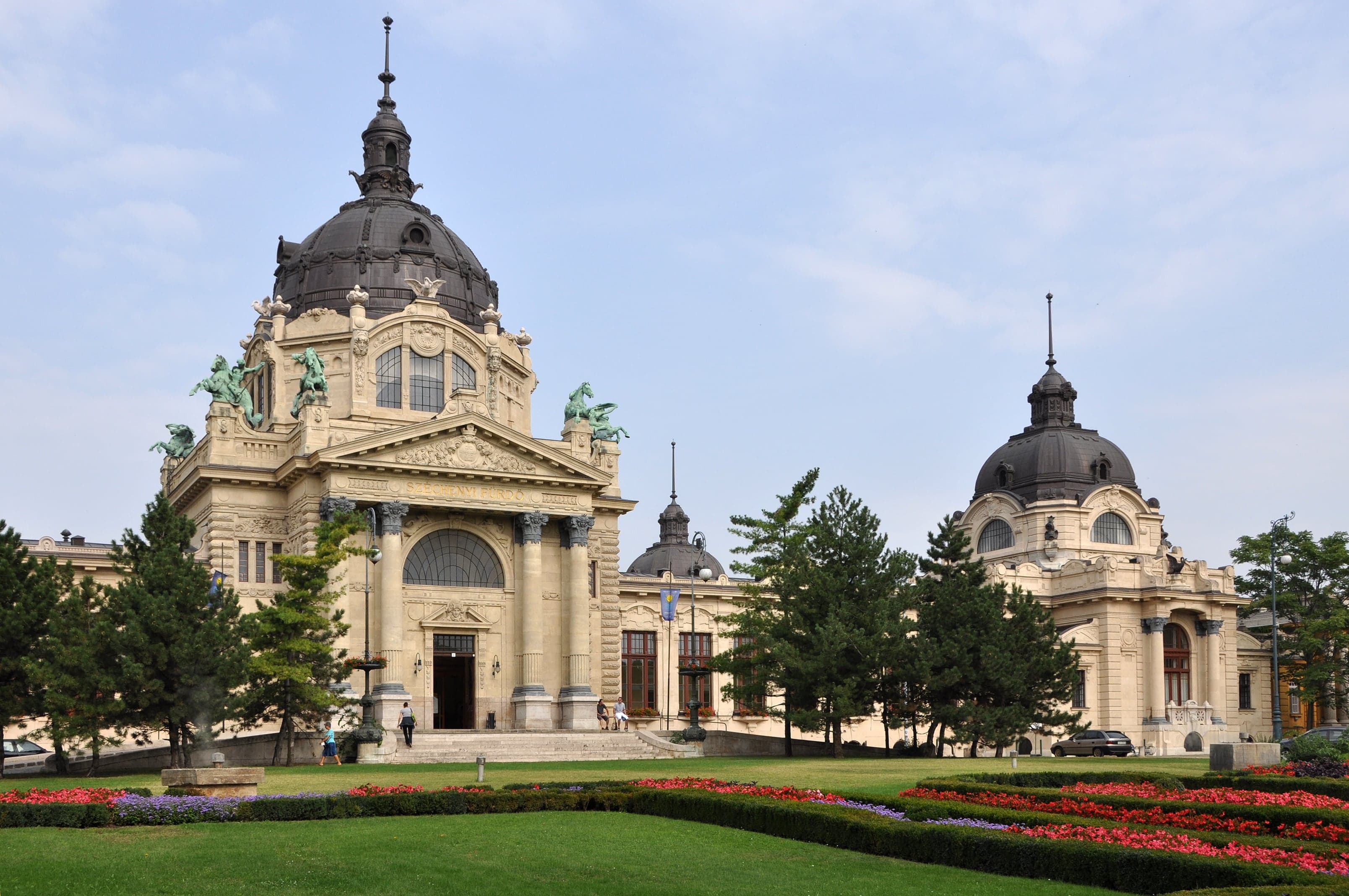People relaxing in the steaming golden outdoor pools of Széchenyi Baths
