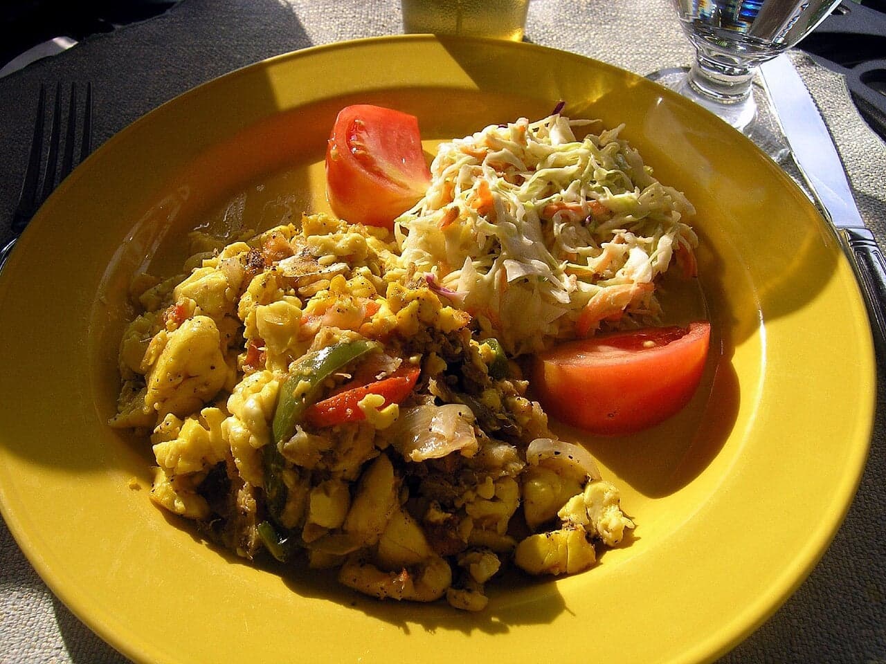 A colourful plate of ackee and saltfish with fried dumplings and plantain