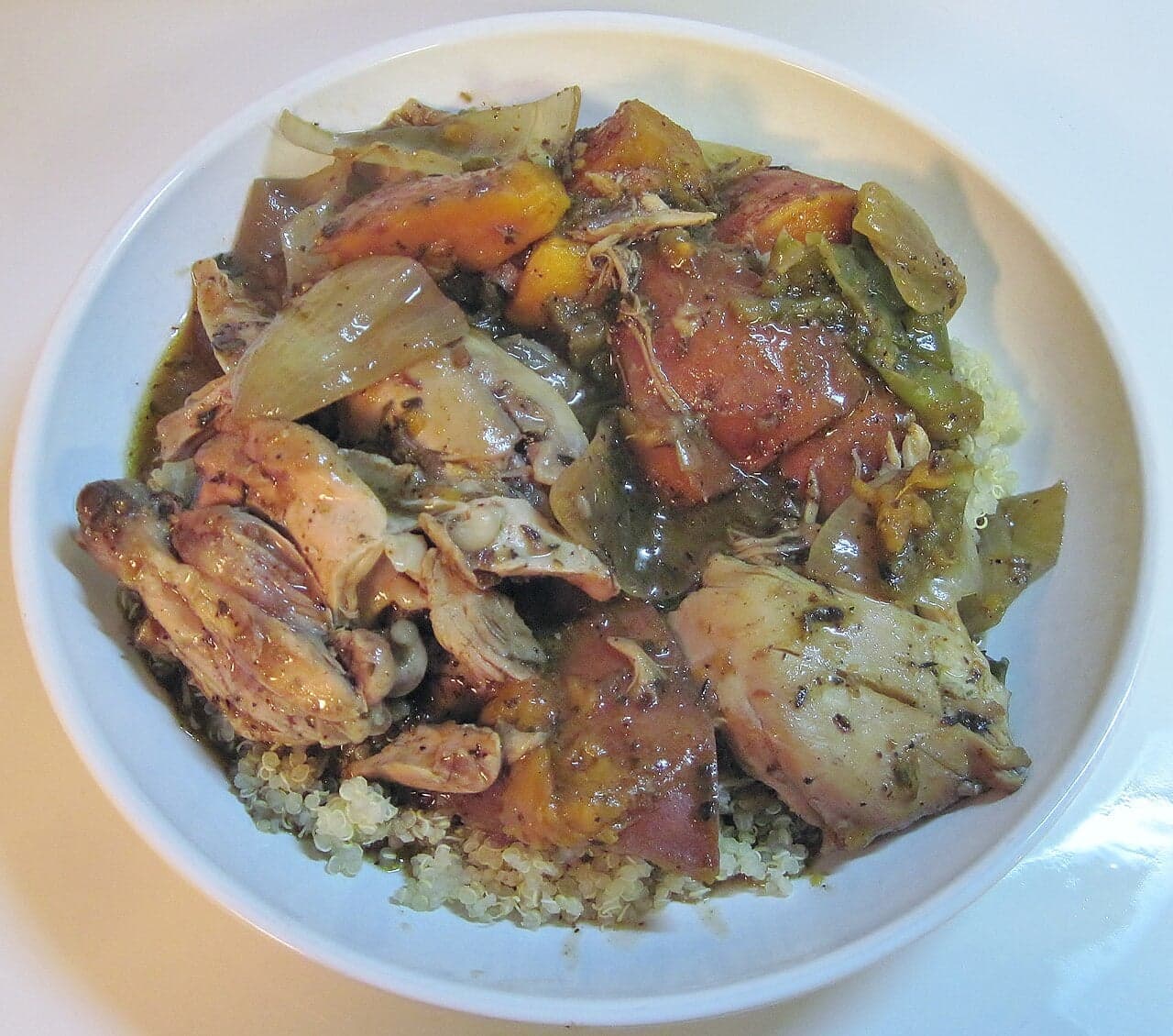 Pieces of jerk chicken sizzling on a smoking grill outdoors in Jamaica