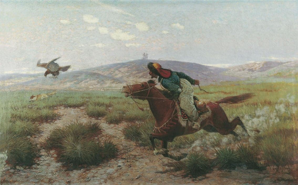 A Kazakh eagle hunter on horseback wearing traditional costume with a golden eagle on their gloved arm
