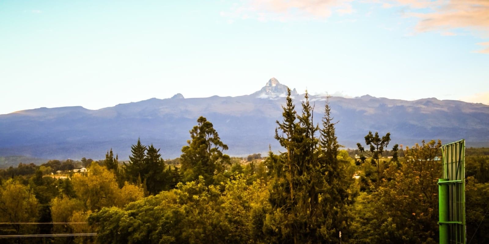 The jagged peaks of Mount Kenya rising above forest