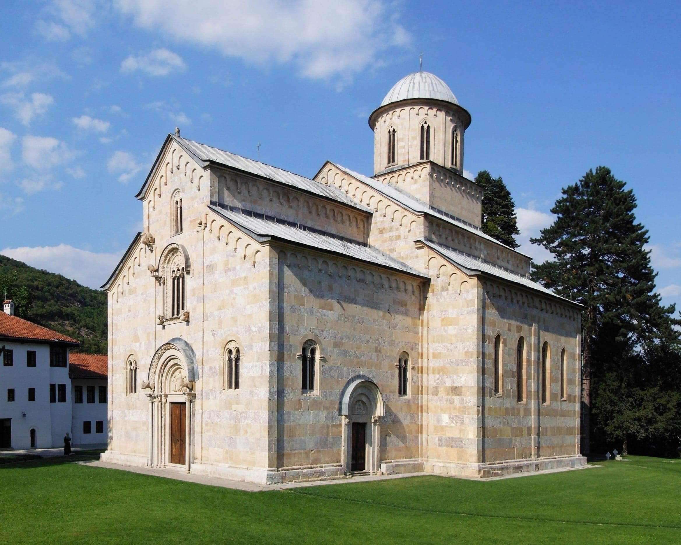 The stone exterior of Visoki Dečani monastery surrounded by forest