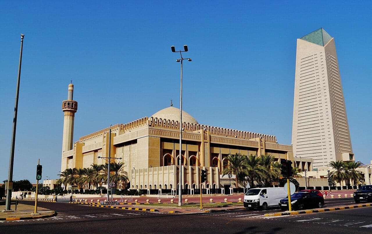 The large dome and tall minaret of the Grand Mosque in Kuwait City against a blue sky