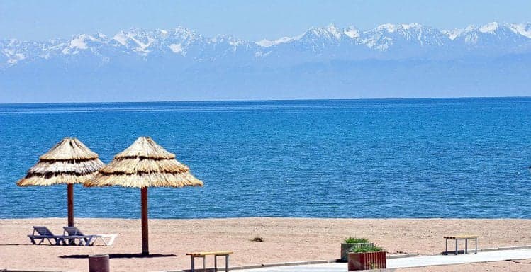 The deep blue waters of Lake Issyk-Kul surrounded by snowy mountains