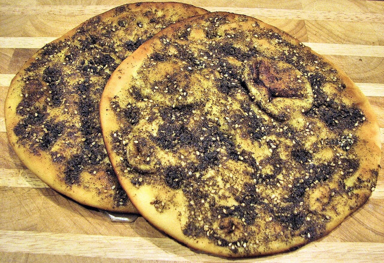A round of fresh manakish bread topped with green za'atar