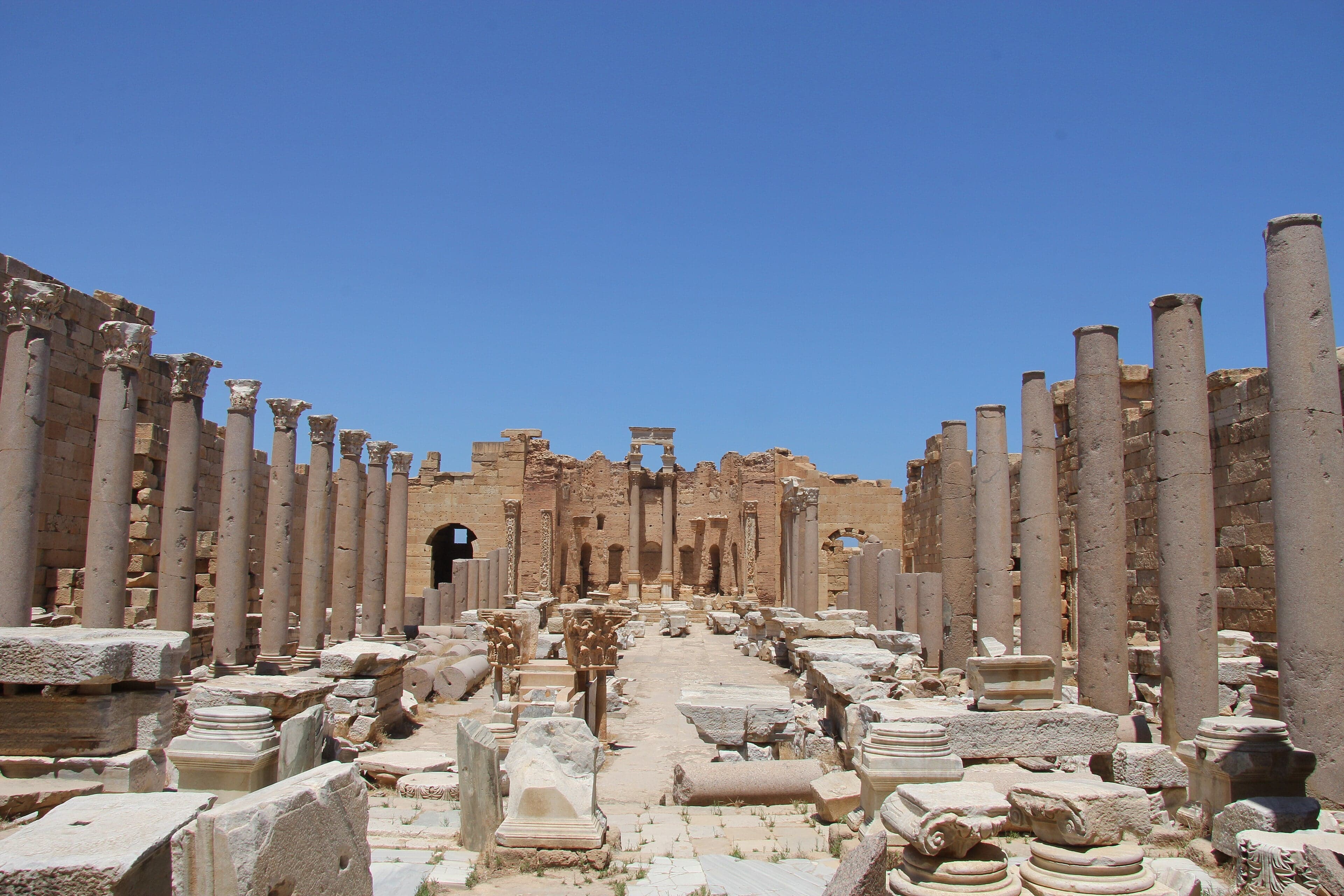 Rows of ancient Roman columns at Leptis Magna rising from golden sand