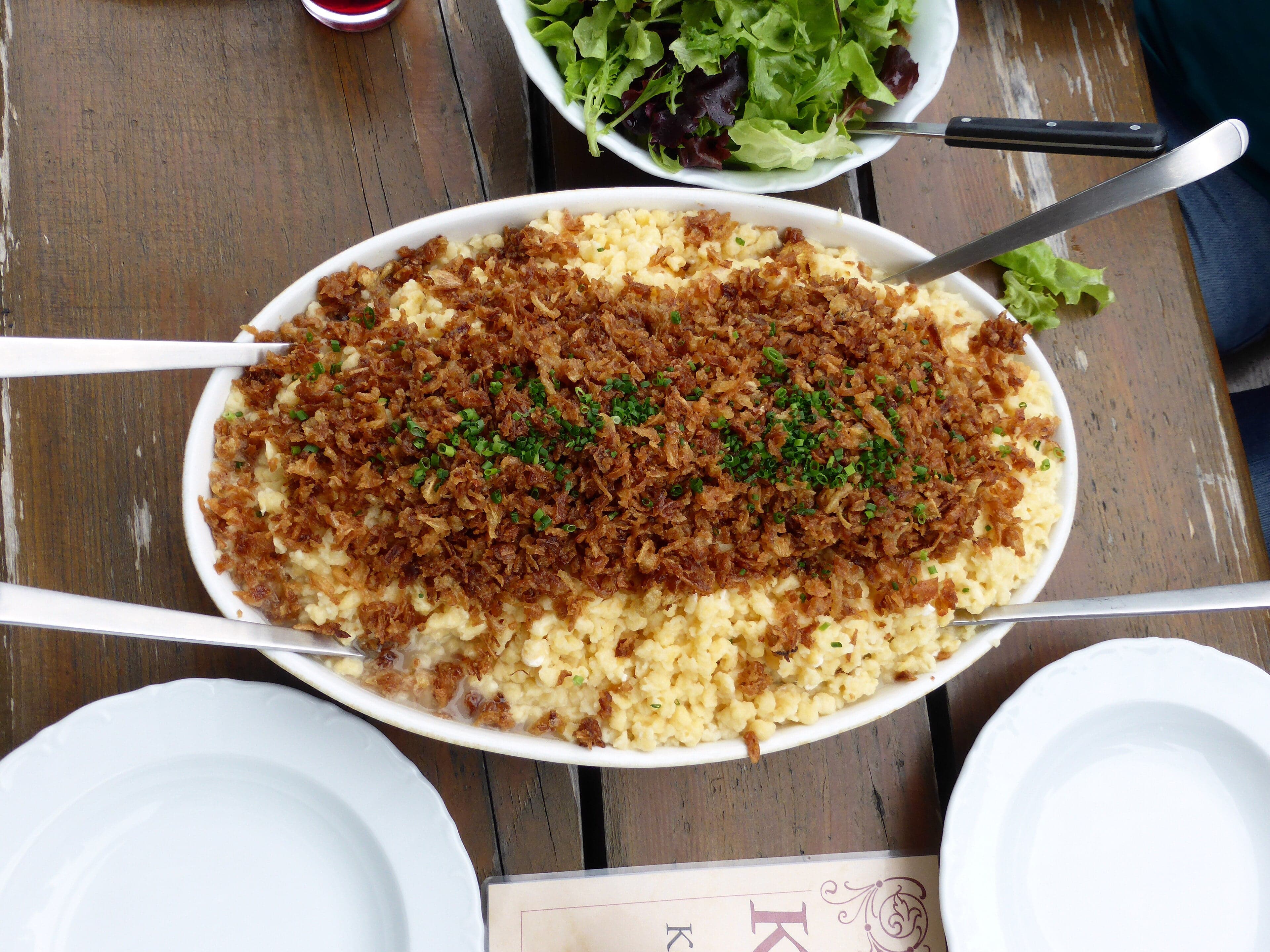 A bowl of Käsknöpfle - small pasta dumplings covered in melted cheese and crispy onions