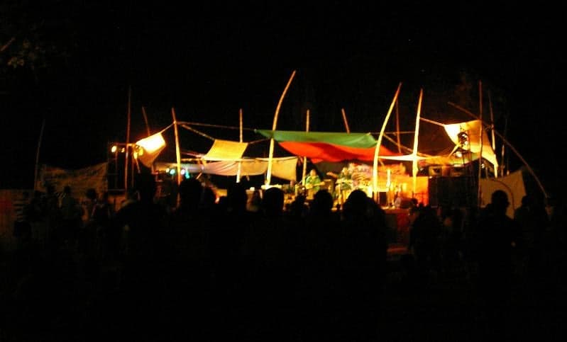 Concert stage lit up with coloured lights on the beach of Lake Malawi at night