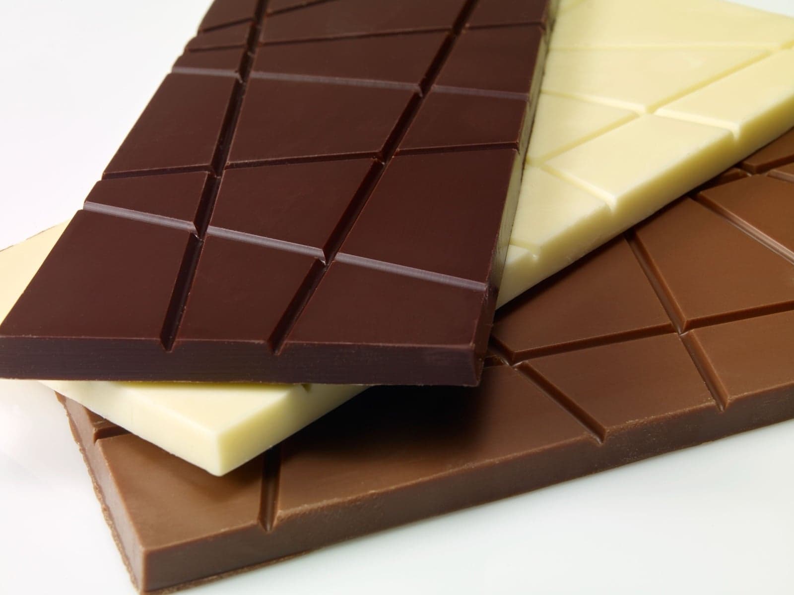 Bars of dark, milk and white chocolate stacked together