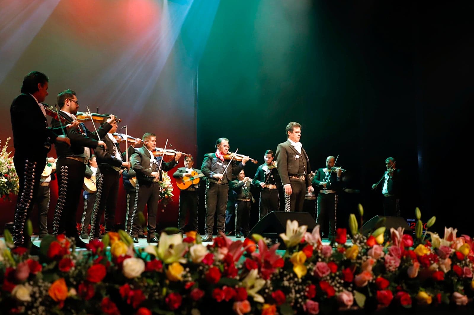 A mariachi band performing on stage with violins and trumpets
