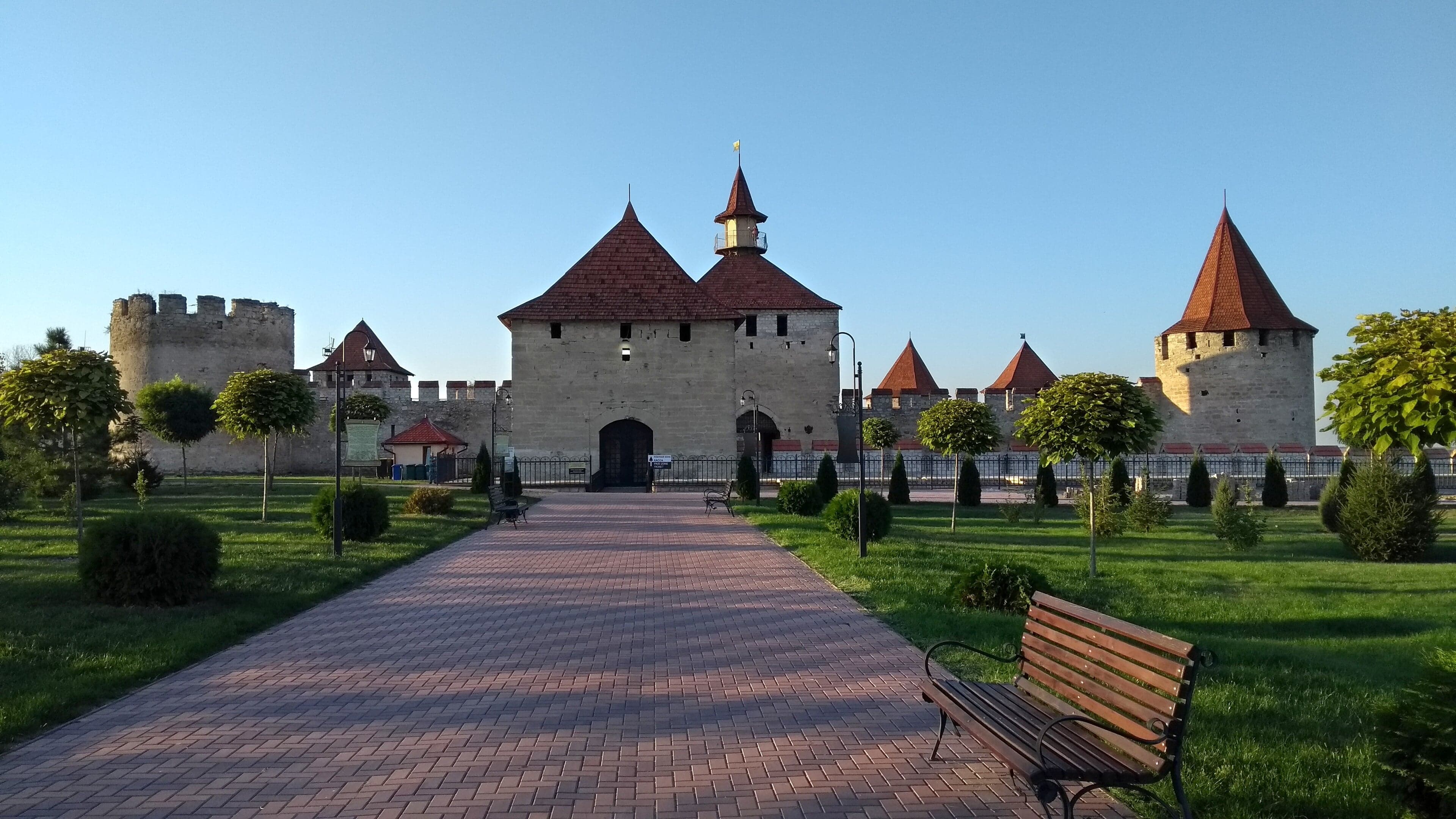 The thick stone walls and towers of Bender Fortress beside a wide river in Moldova