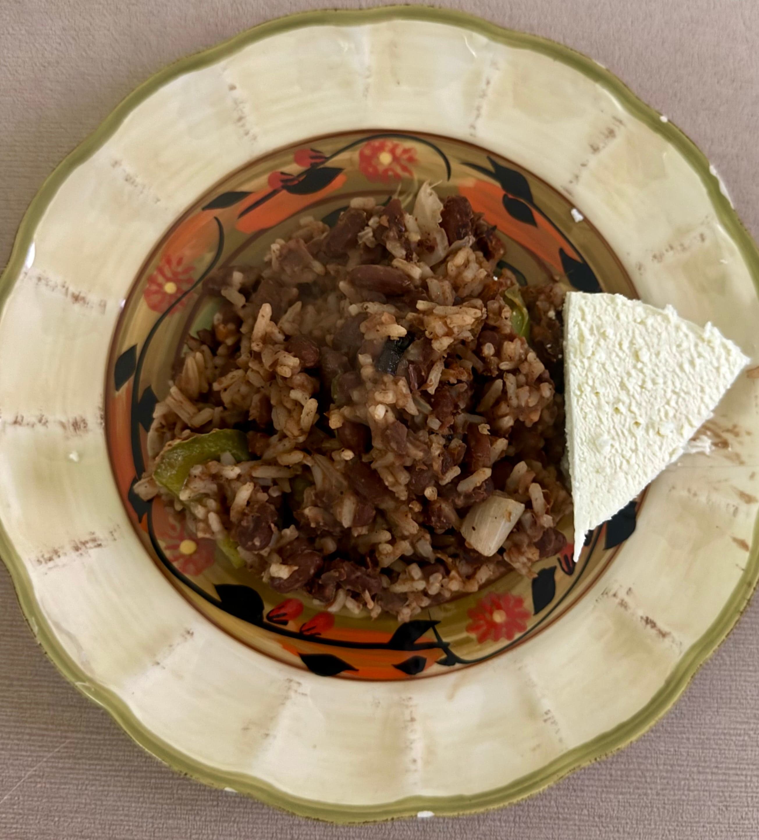 A colourful plate of gallo pinto - rice and red beans fried together - with a fried egg and plantain