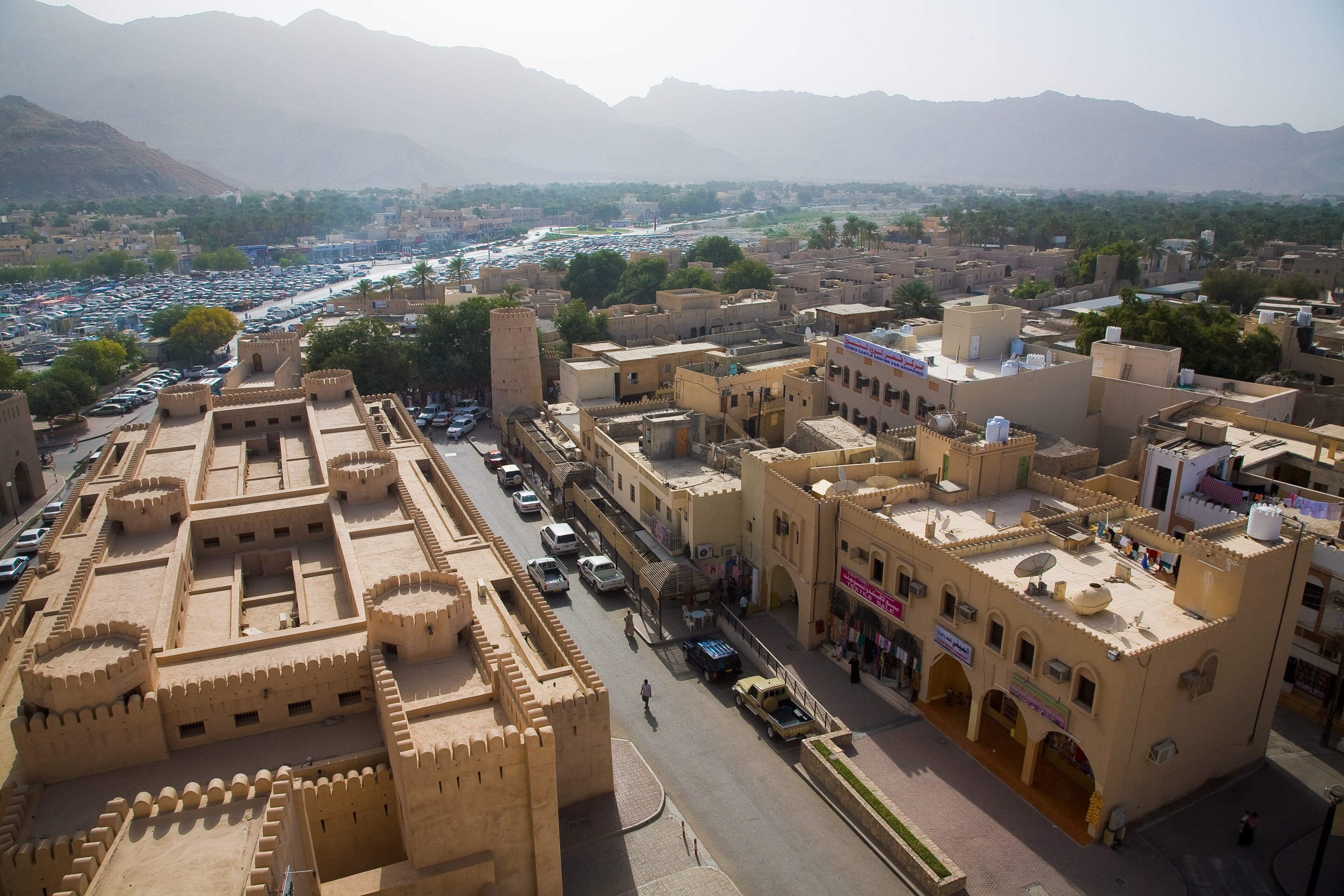The great round tower of Nizwa Fort rising above the Nizwa oasis and souk in Oman