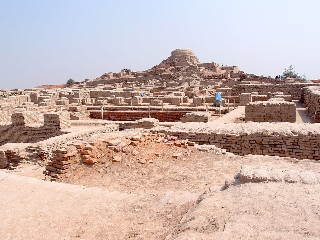 The ancient ruins of Mohenjo-daro, with brick walls and a domed stupa rising above